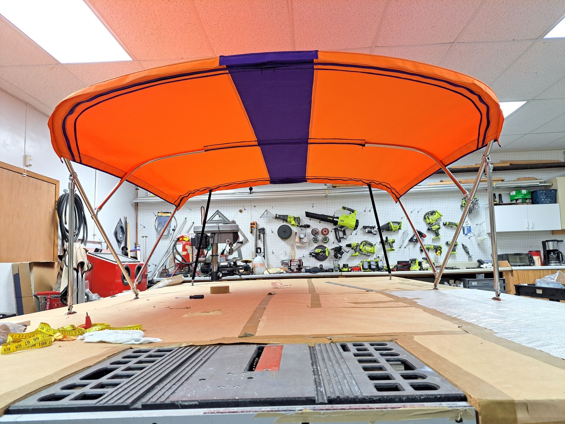 An orange and purple canopy is sitting on top of a wooden table.