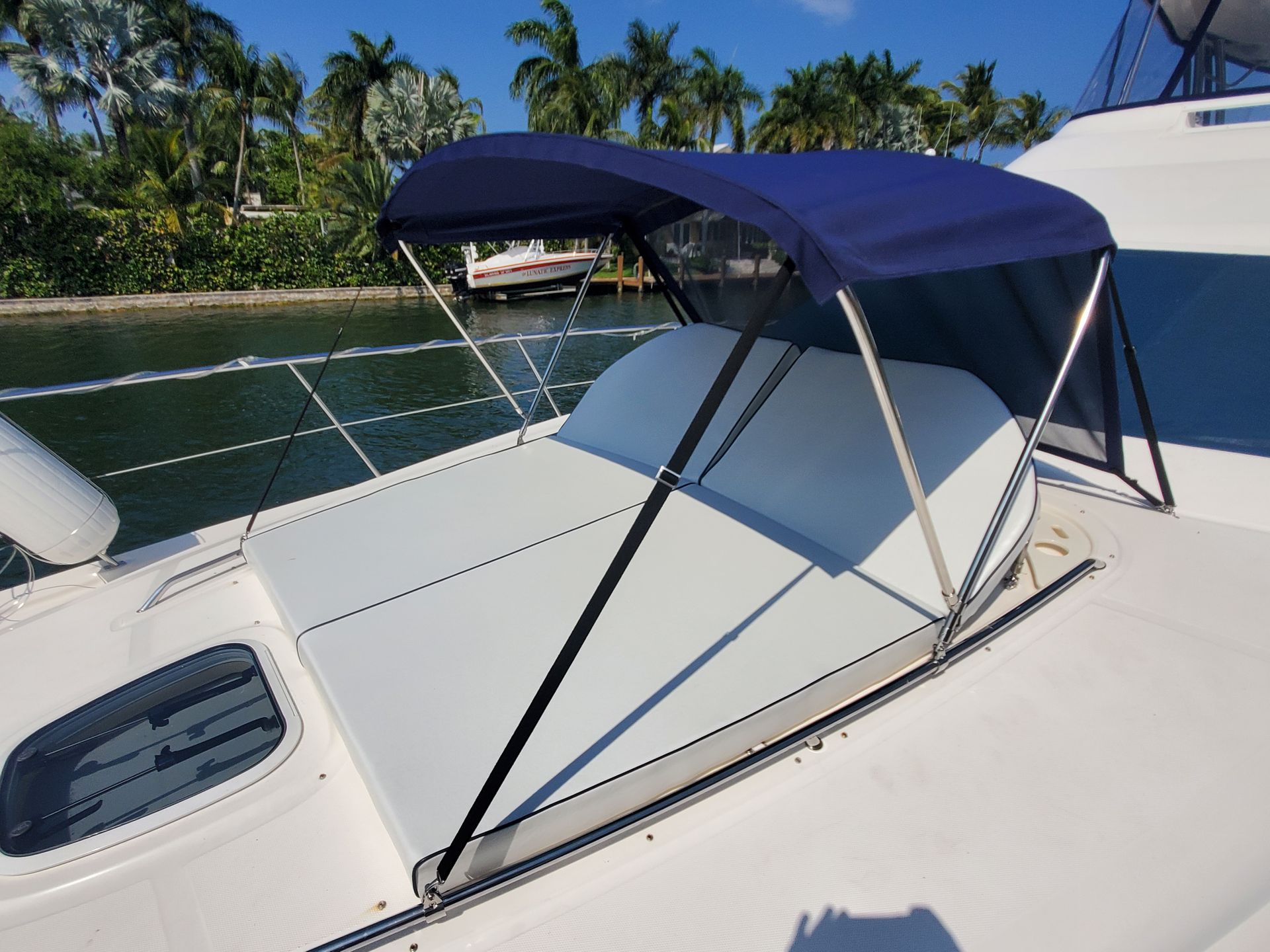 A white boat with a blue canopy on top of it