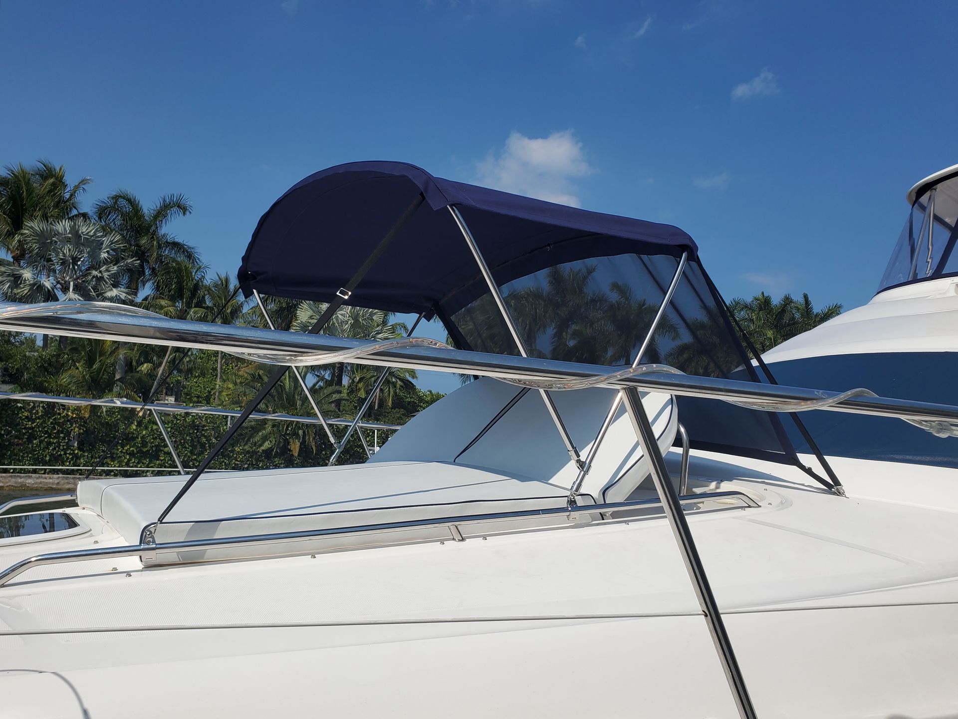 A white boat with a blue canopy on top of it