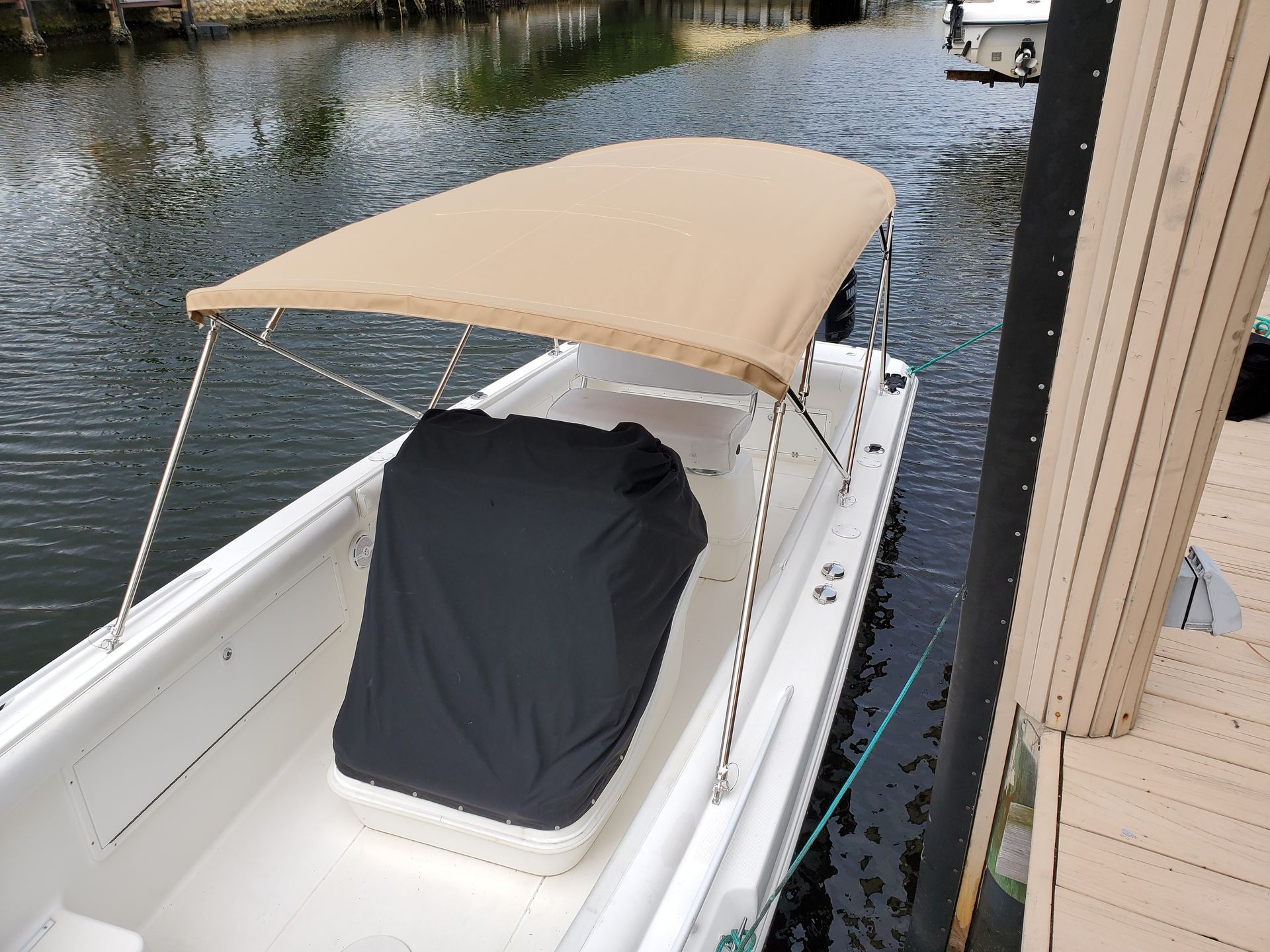A boat with a canopy is docked at a dock