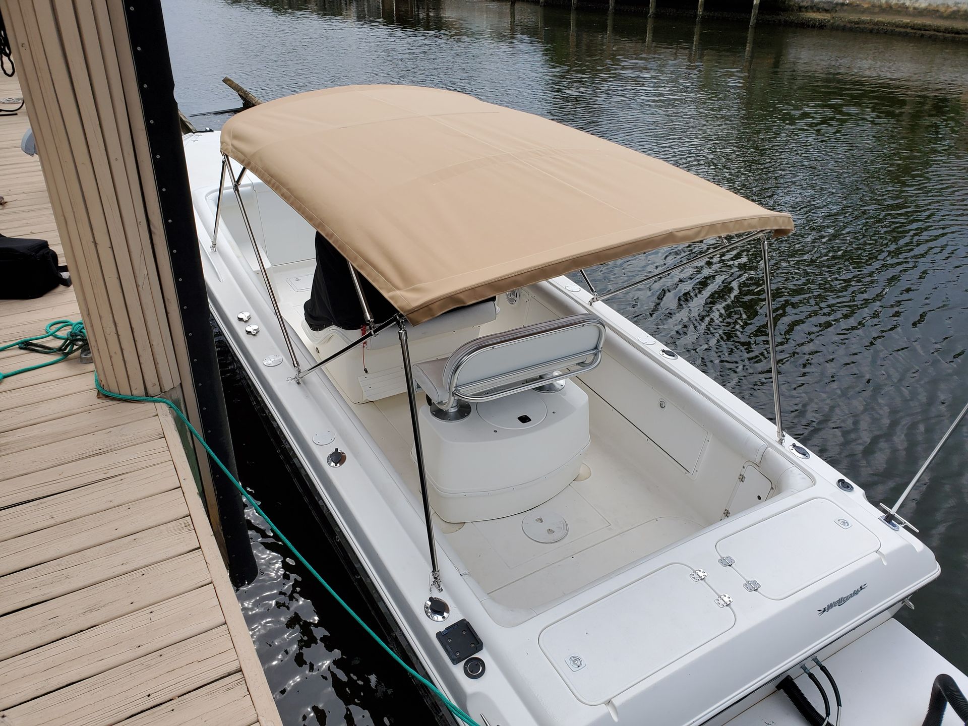 A boat with a canopy is docked at a dock