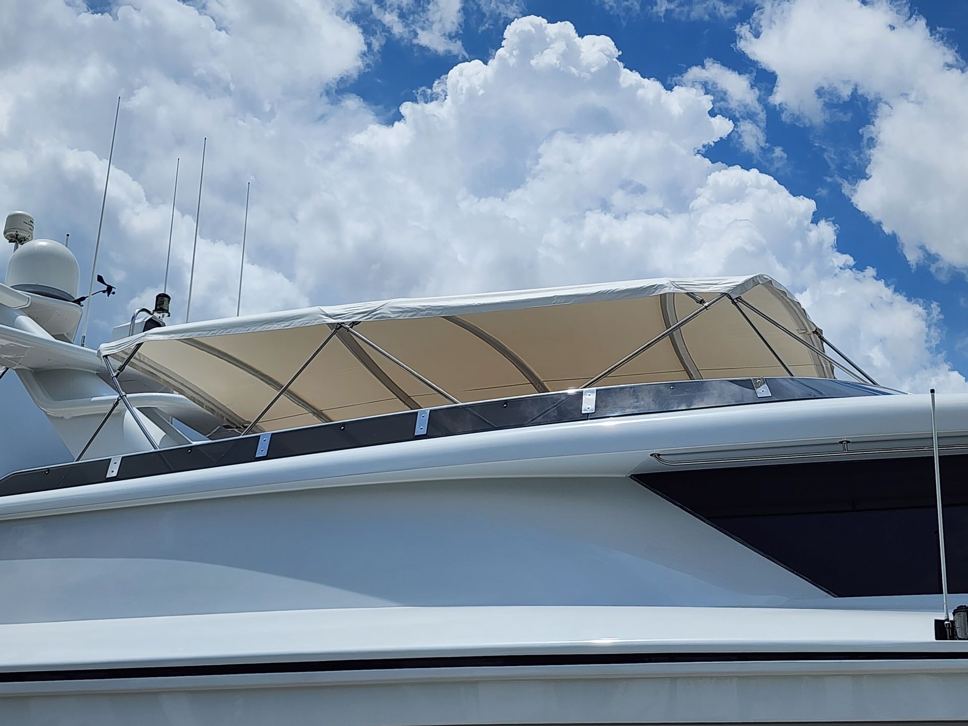 A boat with a canopy on top of it and a blue sky with clouds in the background.