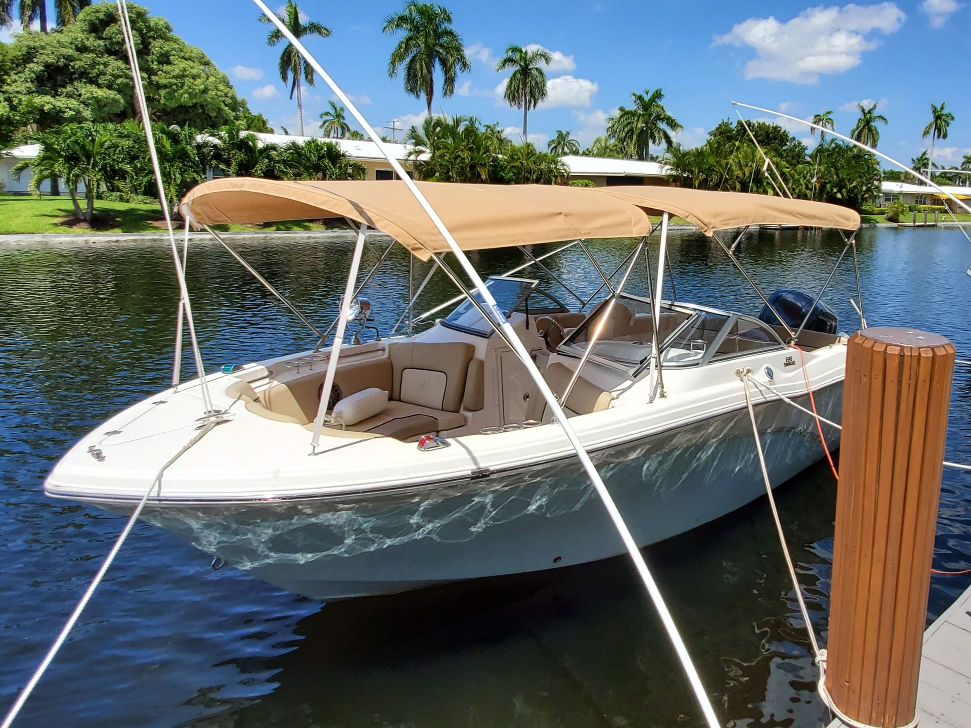 A boat with a canopy is docked at a dock