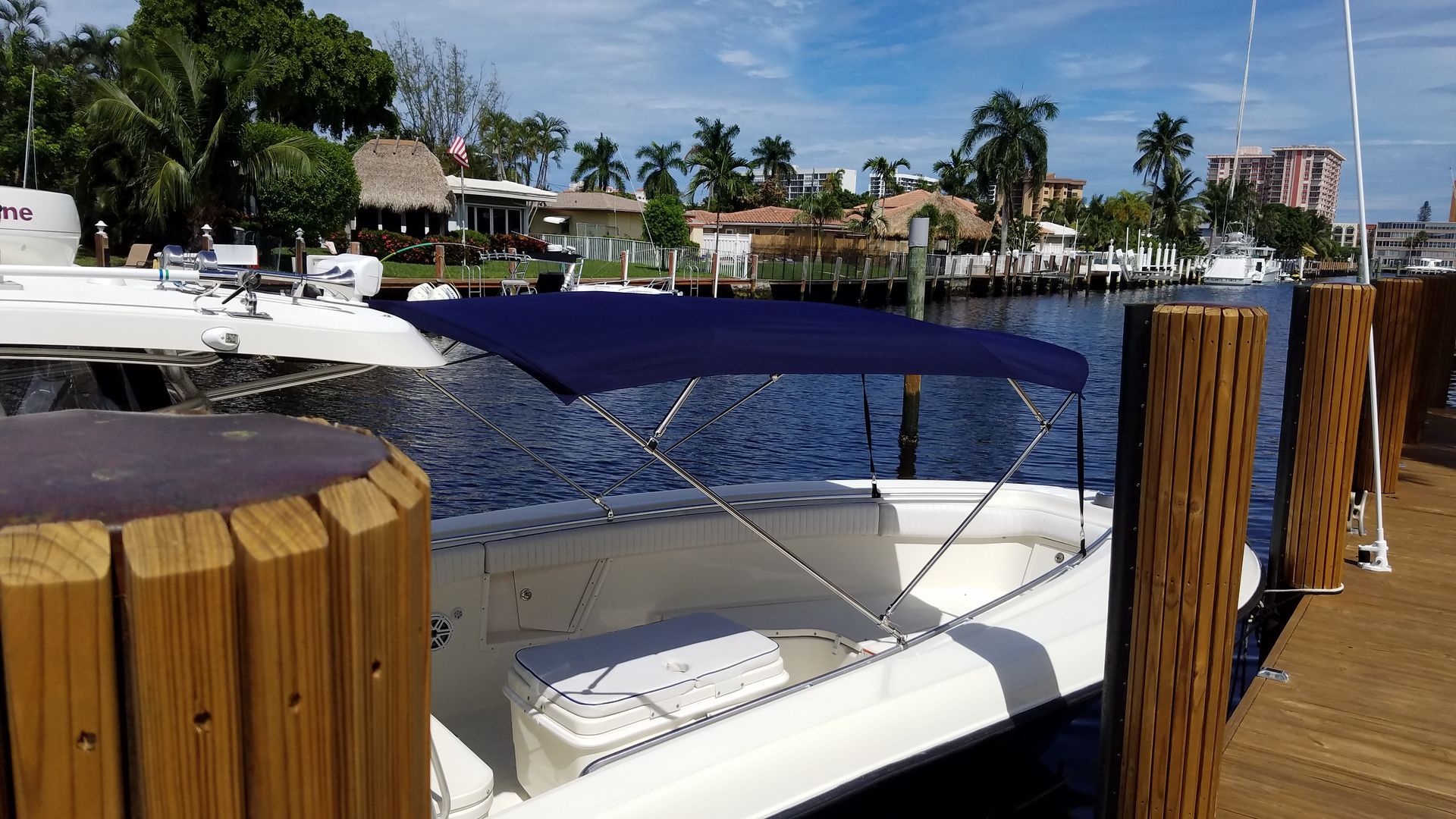 A boat with a blue canopy is docked at a dock