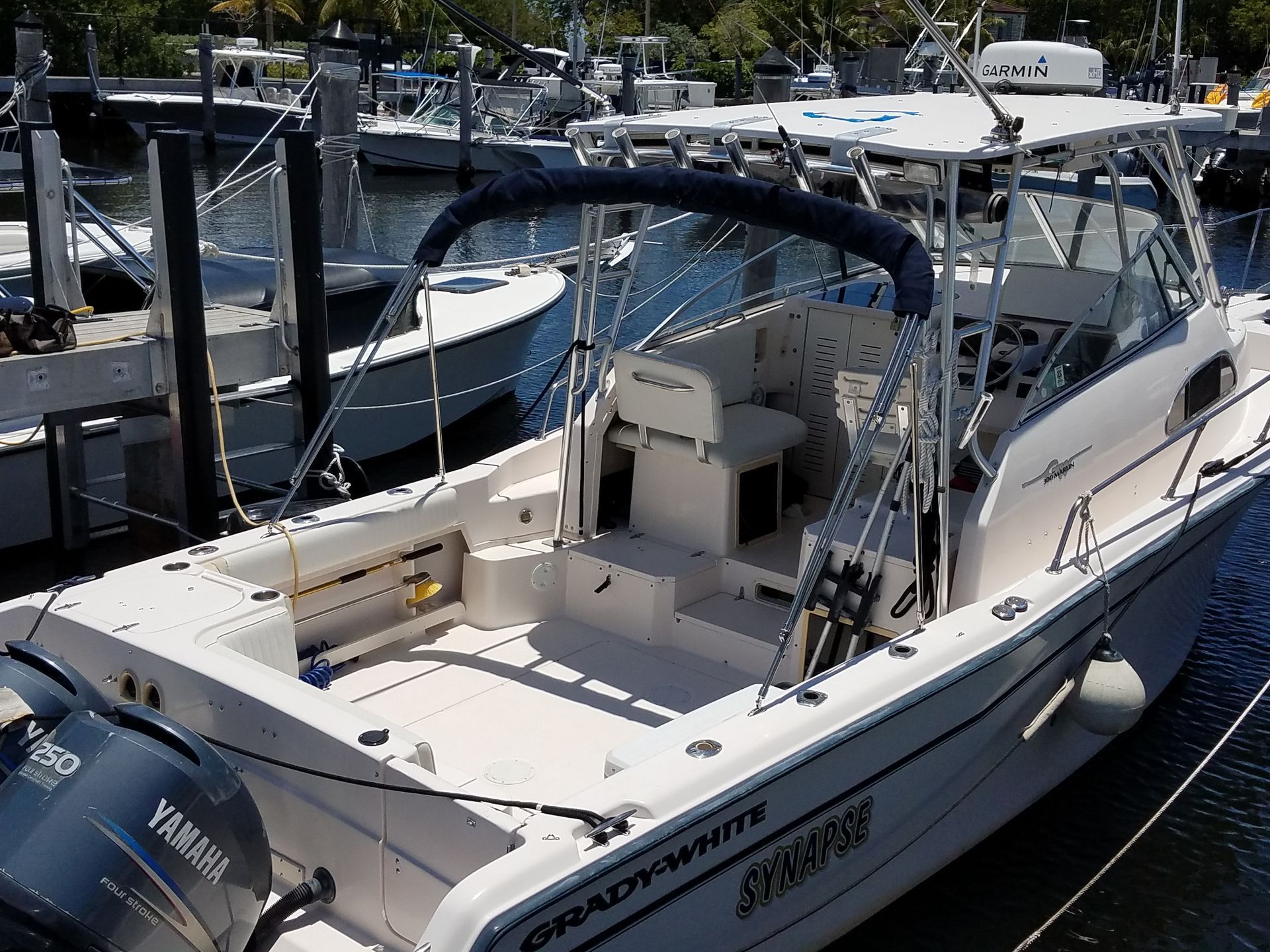 A white yamaha boat is docked in a marina