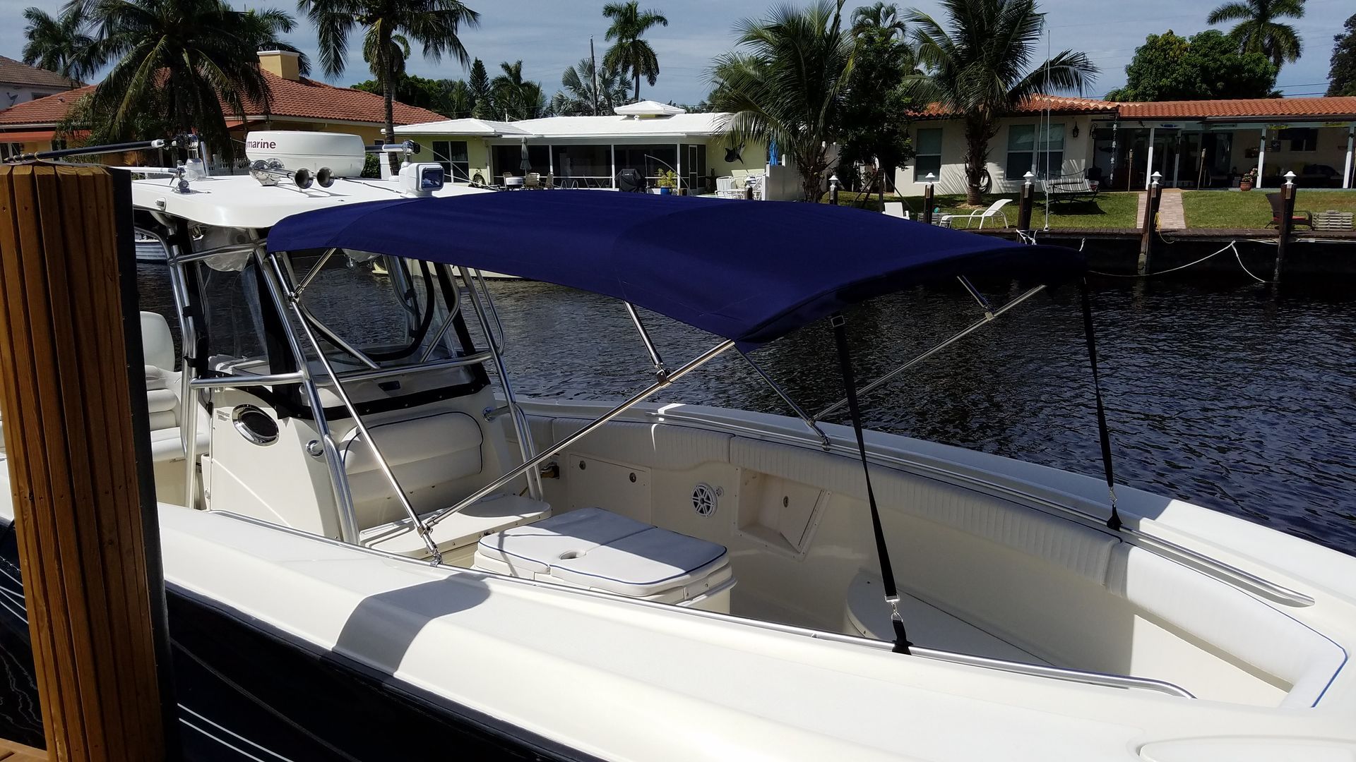 A boat with a blue canopy is docked in the water