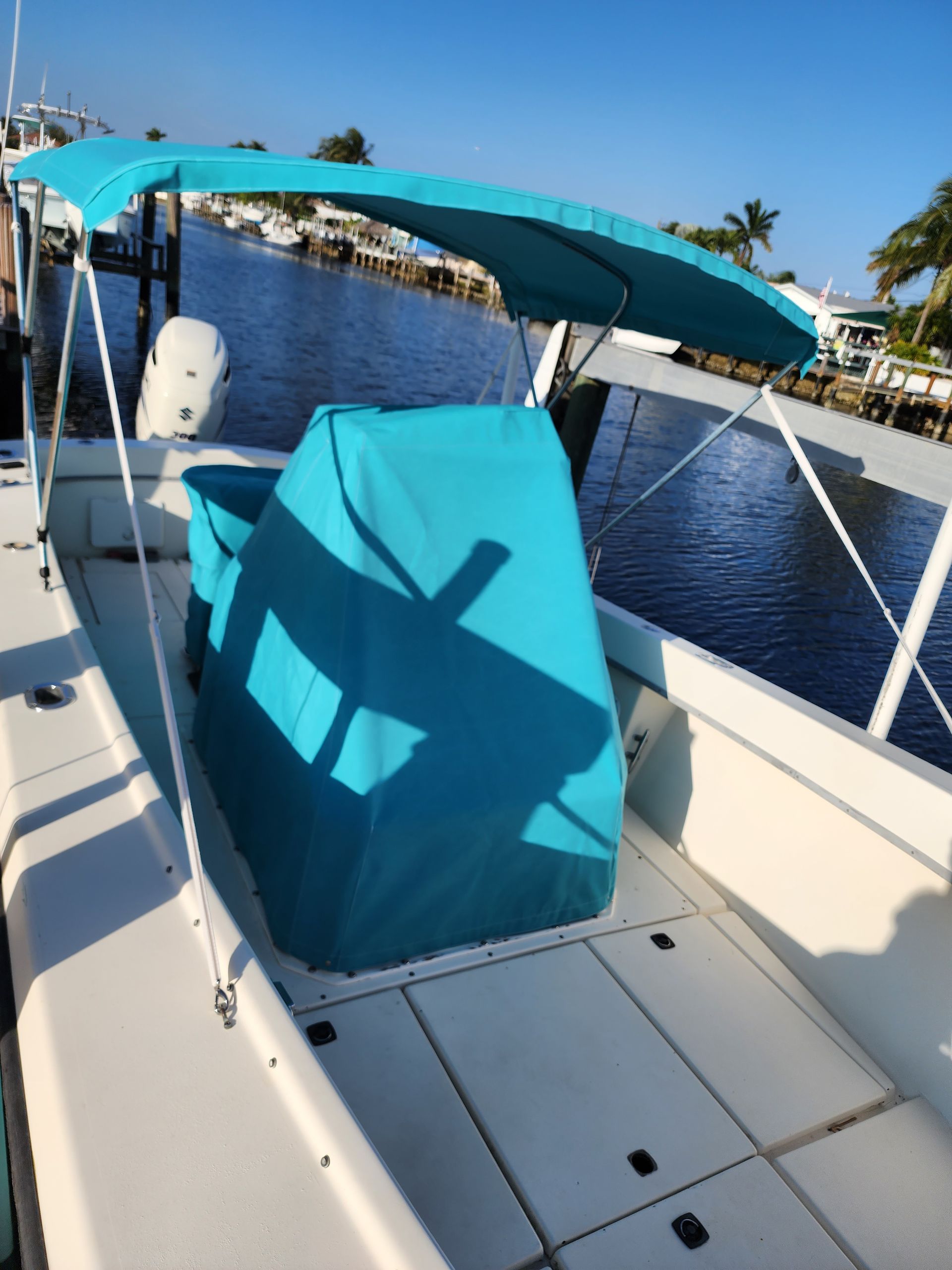 A white boat with a blue canopy on top of it