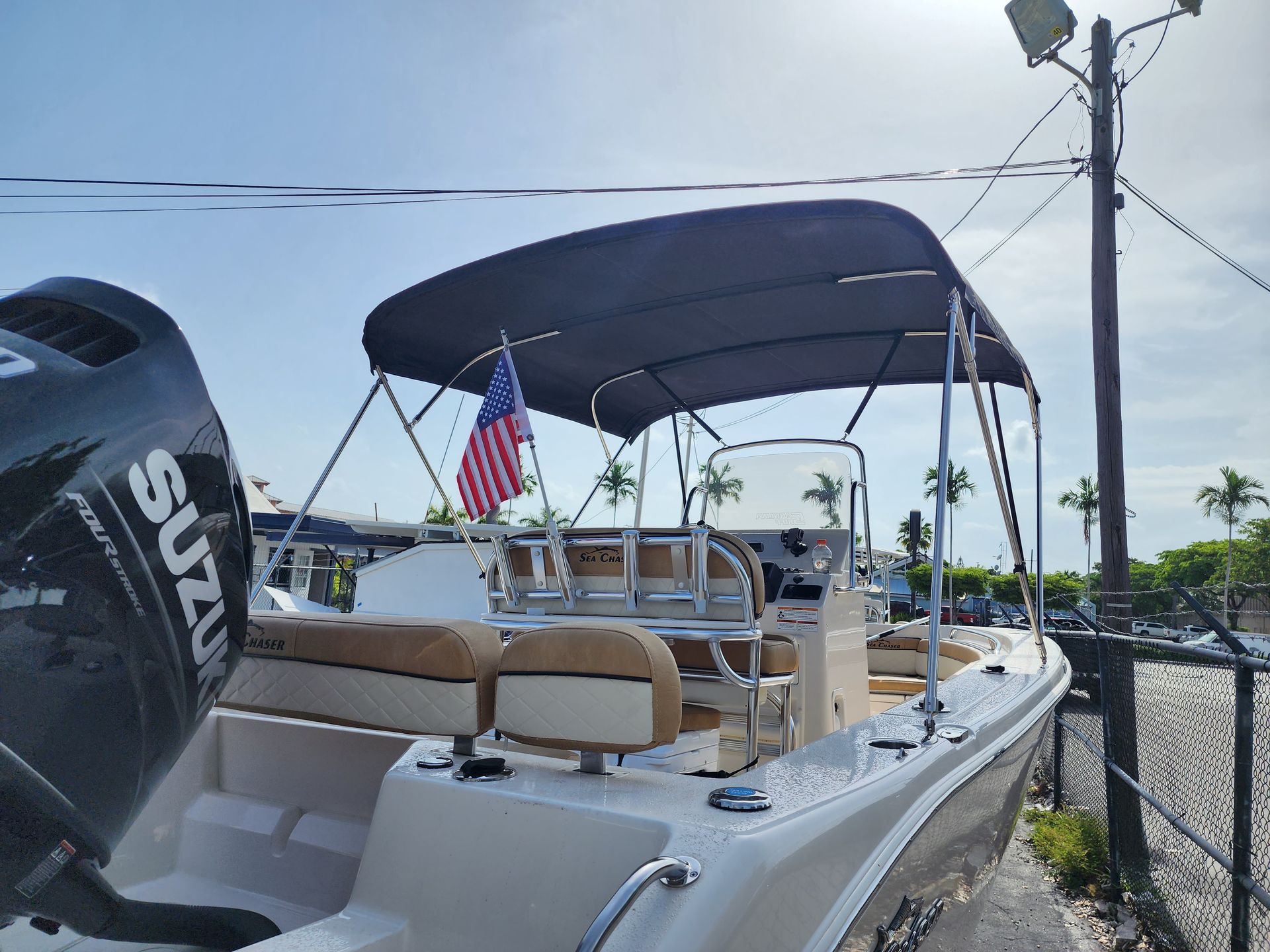 A boat with a suzuki engine is parked next to a fence