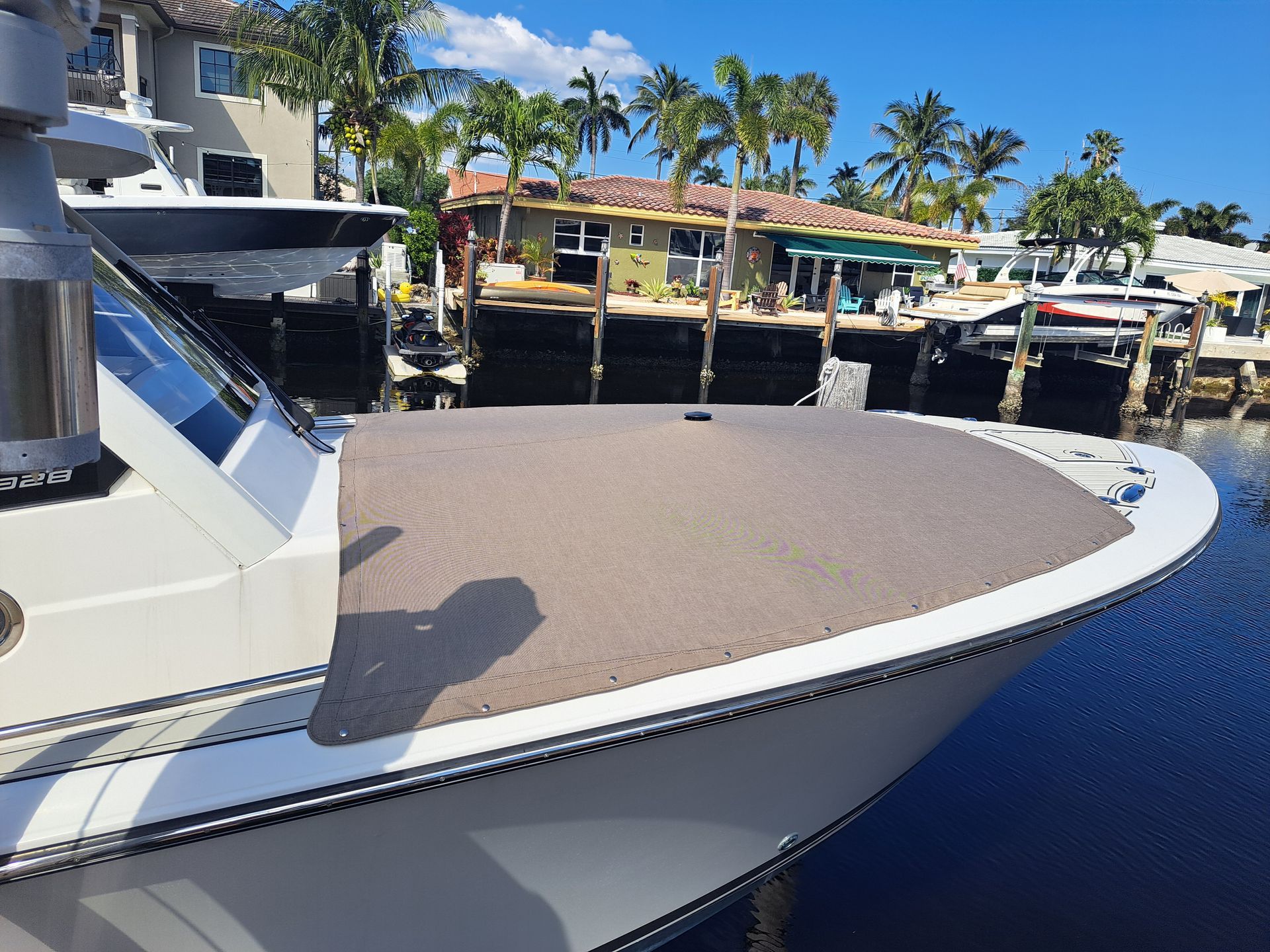 A boat is docked in a marina with palm trees in the background