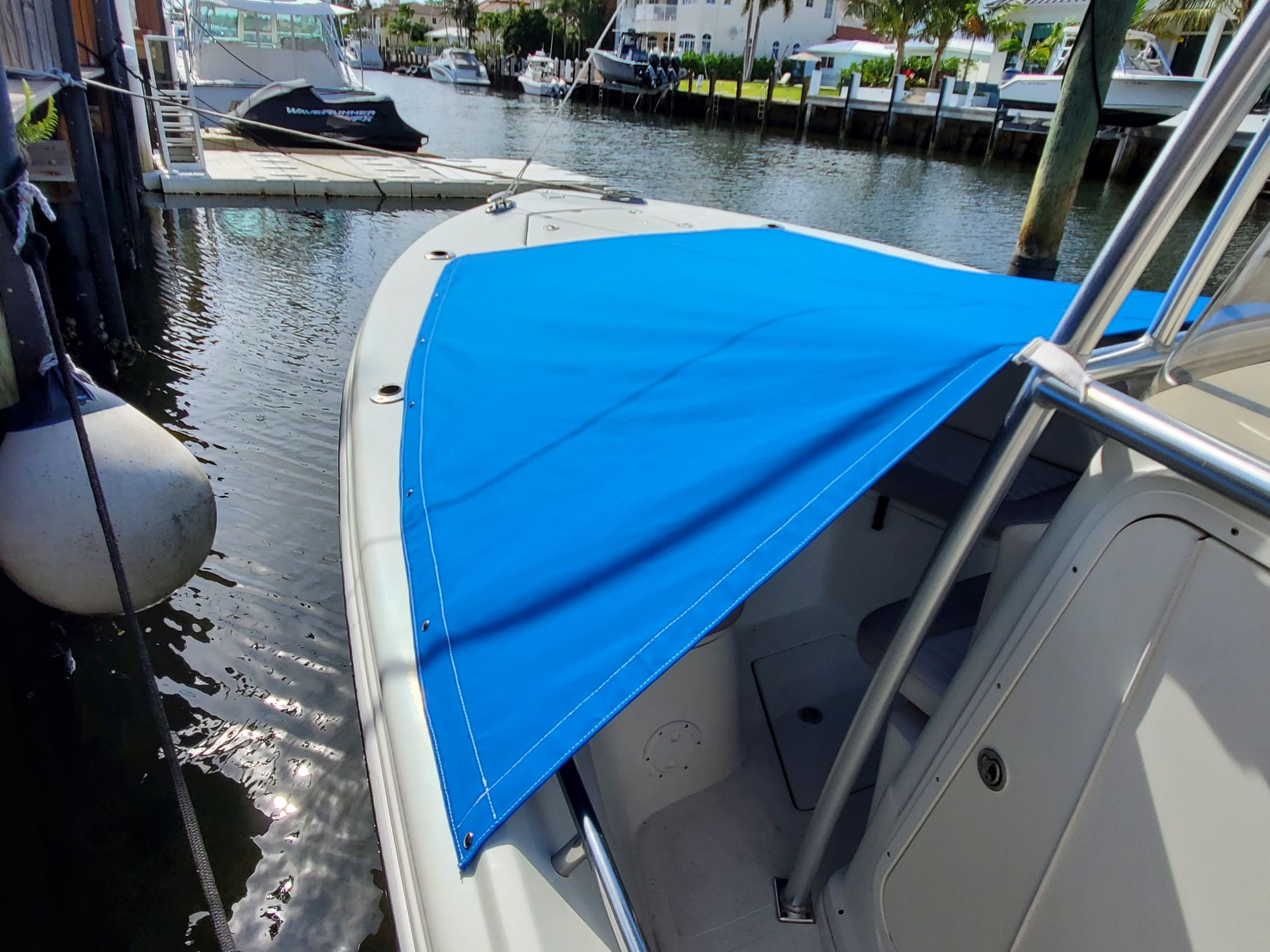 A boat with a blue canopy is docked in the water