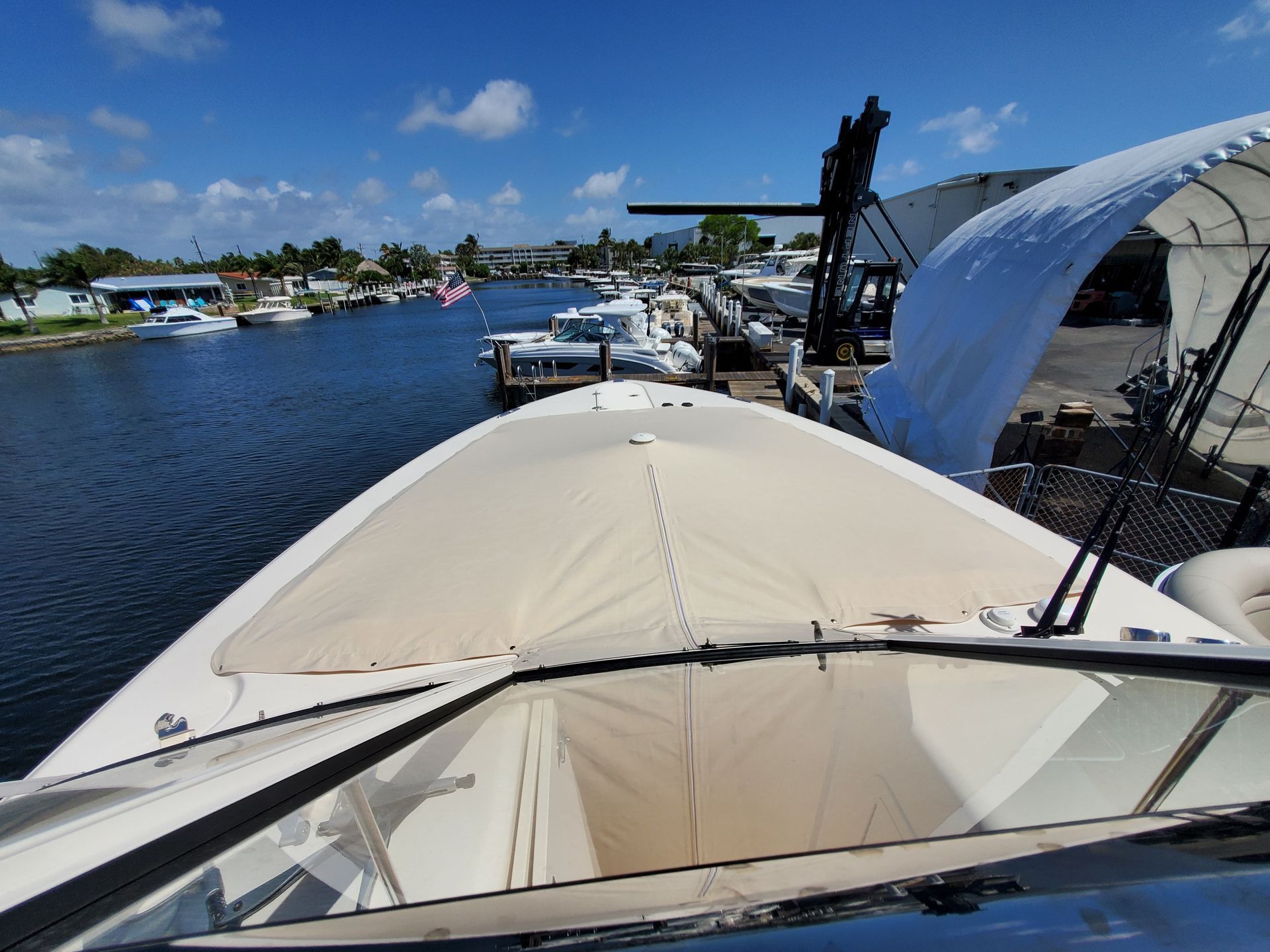 A boat is docked in a marina with its hood up.