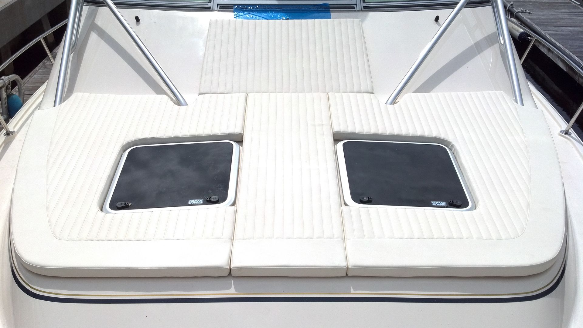 The front of a boat with a cushion and two windows