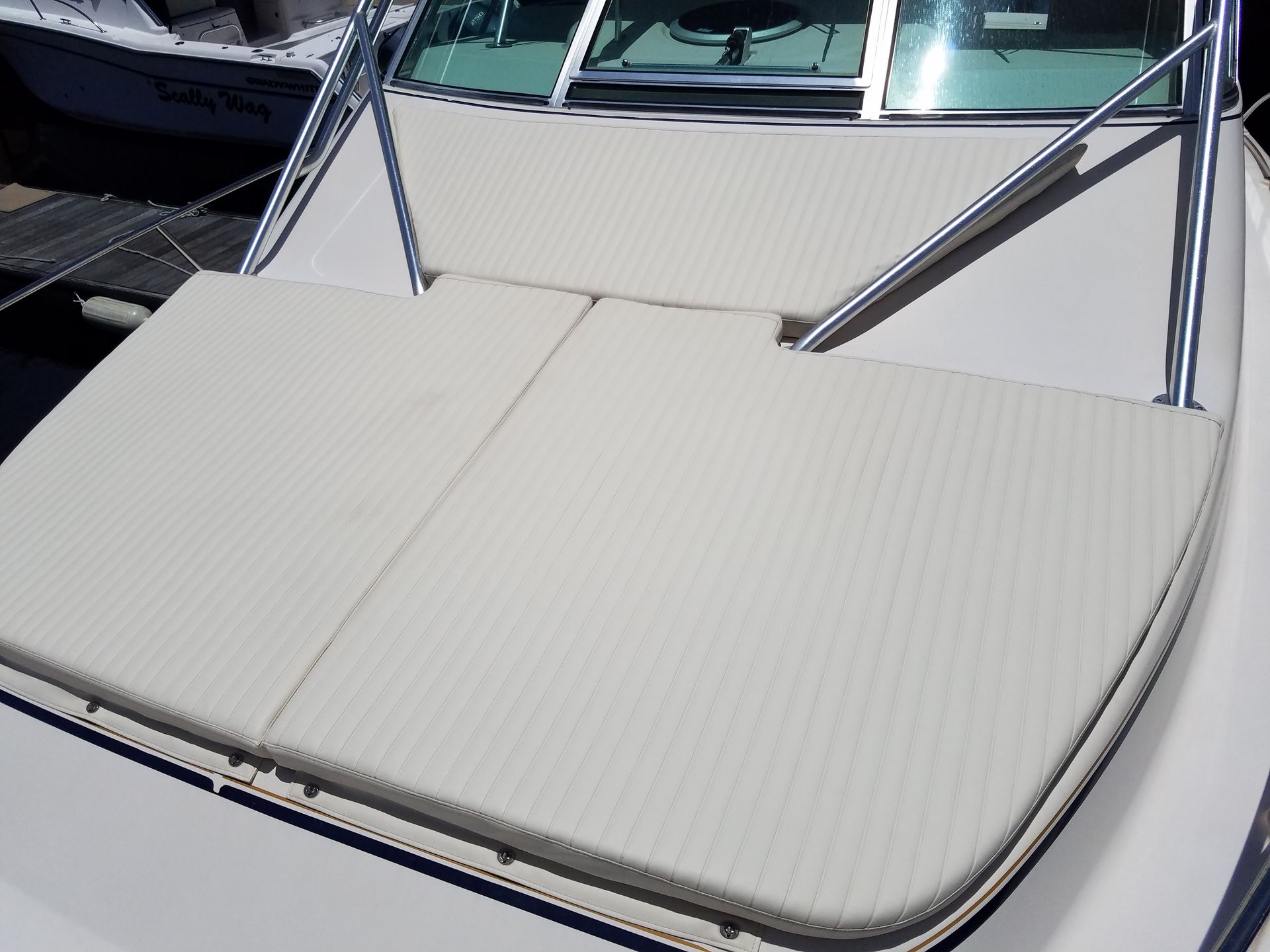 A white boat with a cushion on the back of it