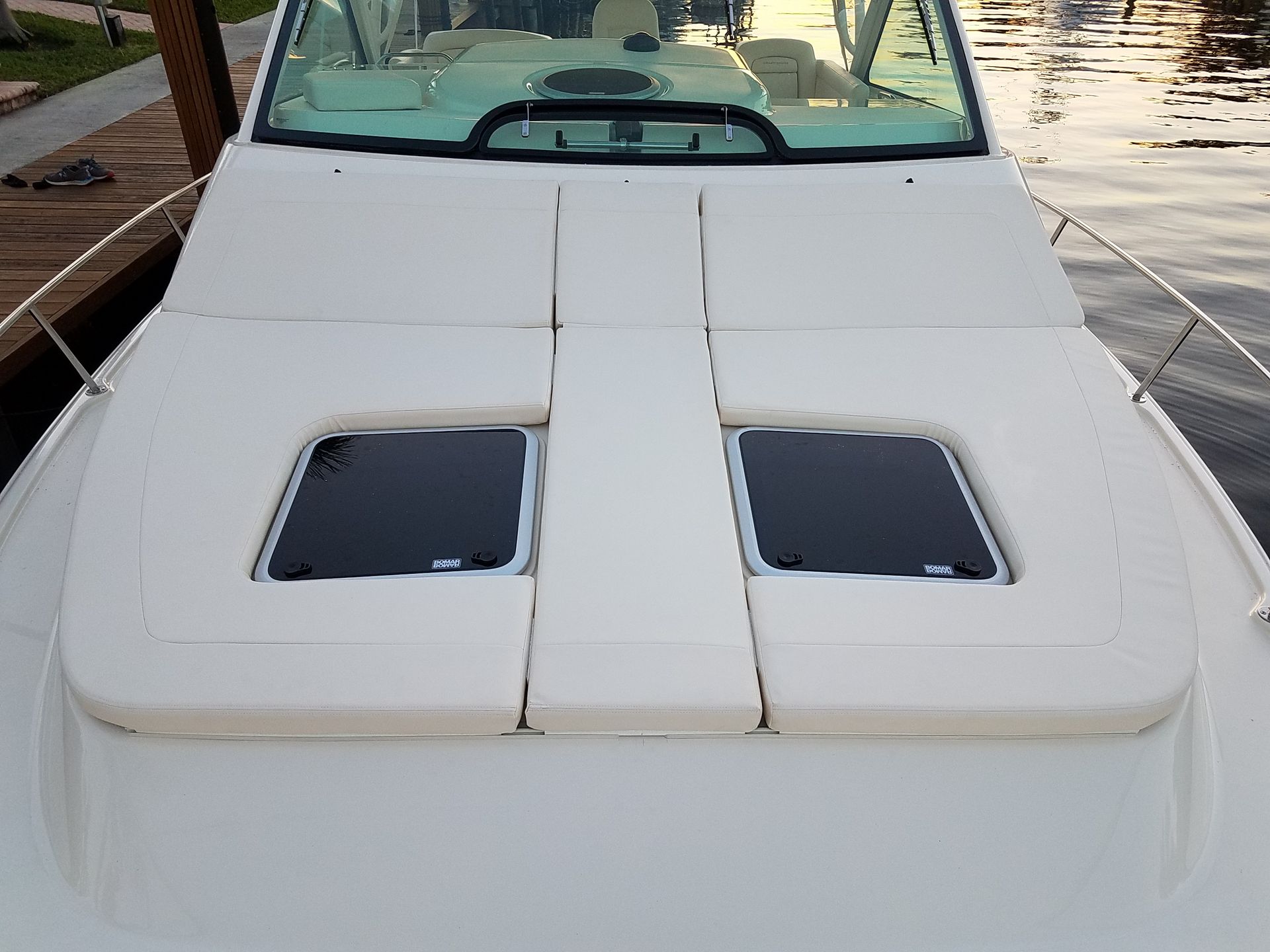 The front of a white boat is sitting in the water.