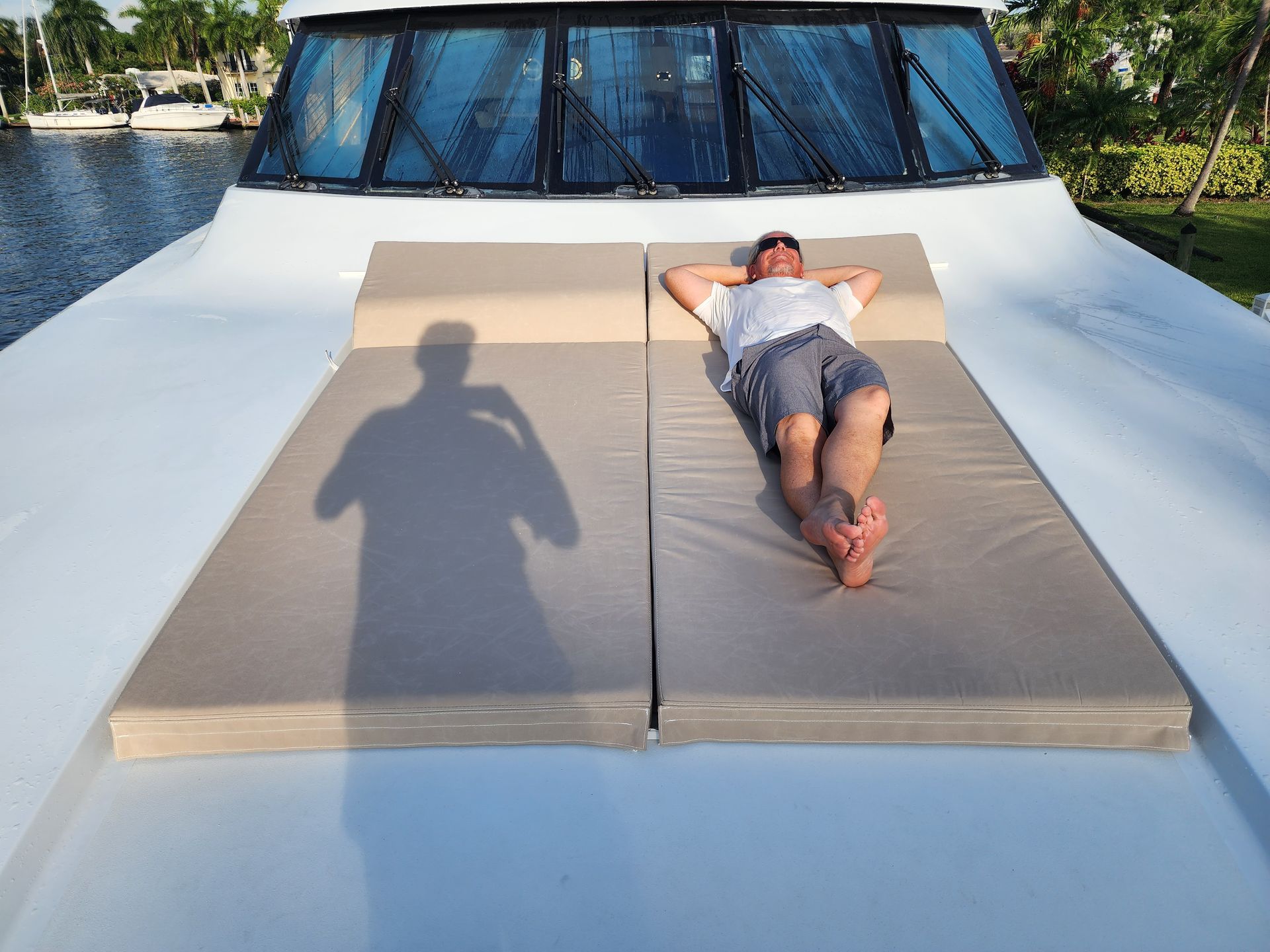 A man is laying on the front of a boat.