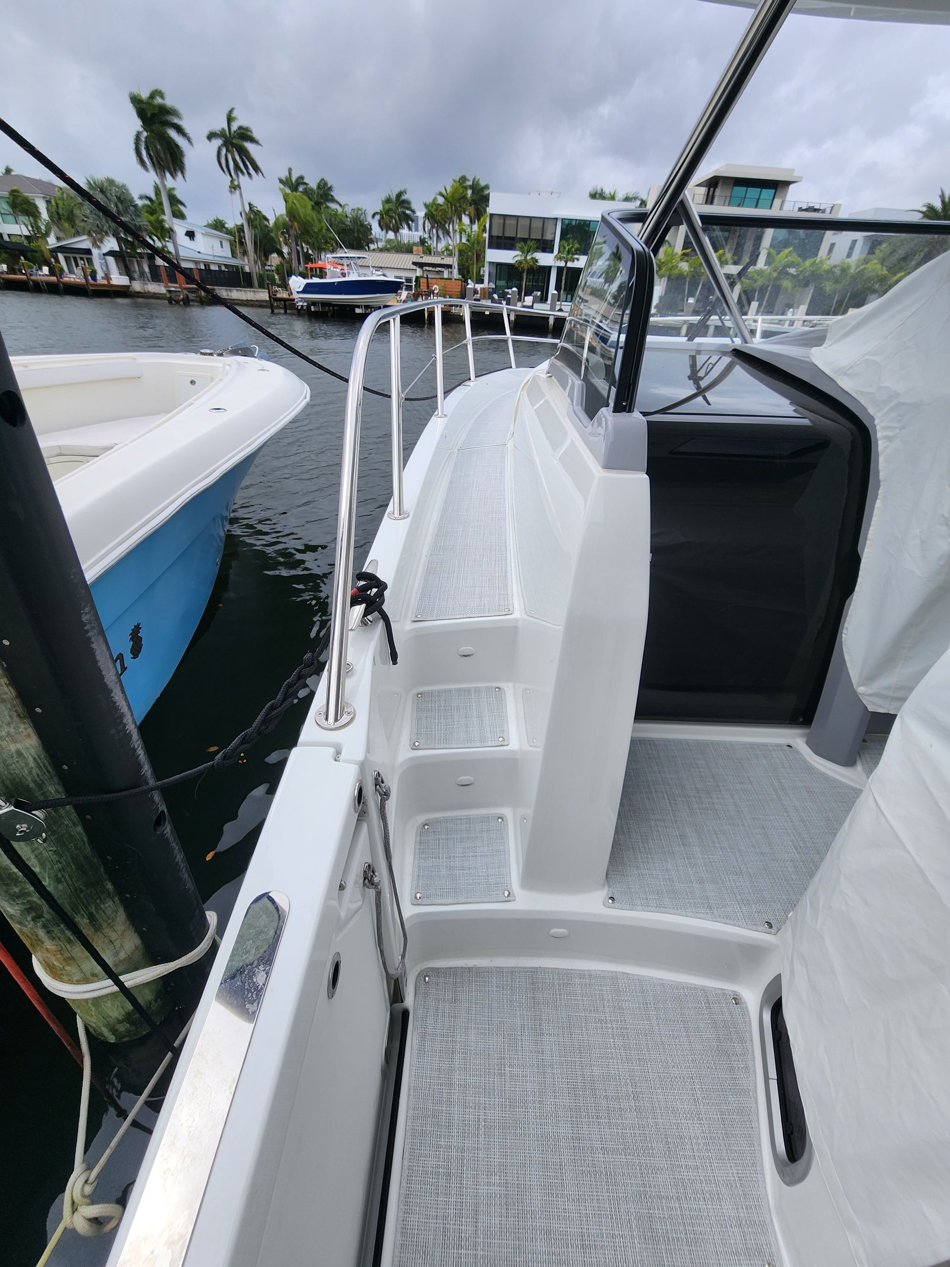 A boat is docked in a marina with a blue boat in the background.