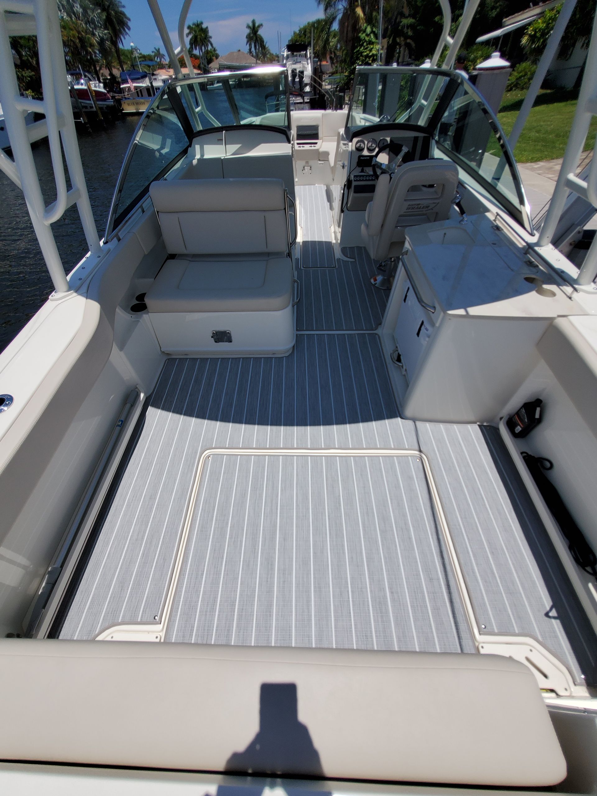 The inside of a boat with a gray cushion on the seat.