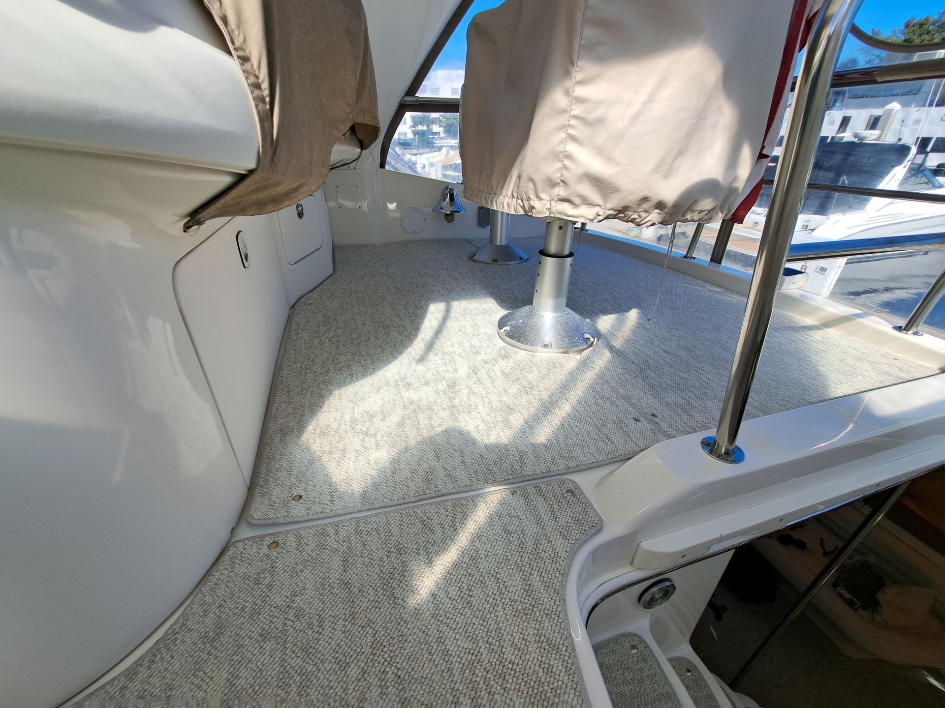 A boat with a carpeted floor and a chair on the deck.