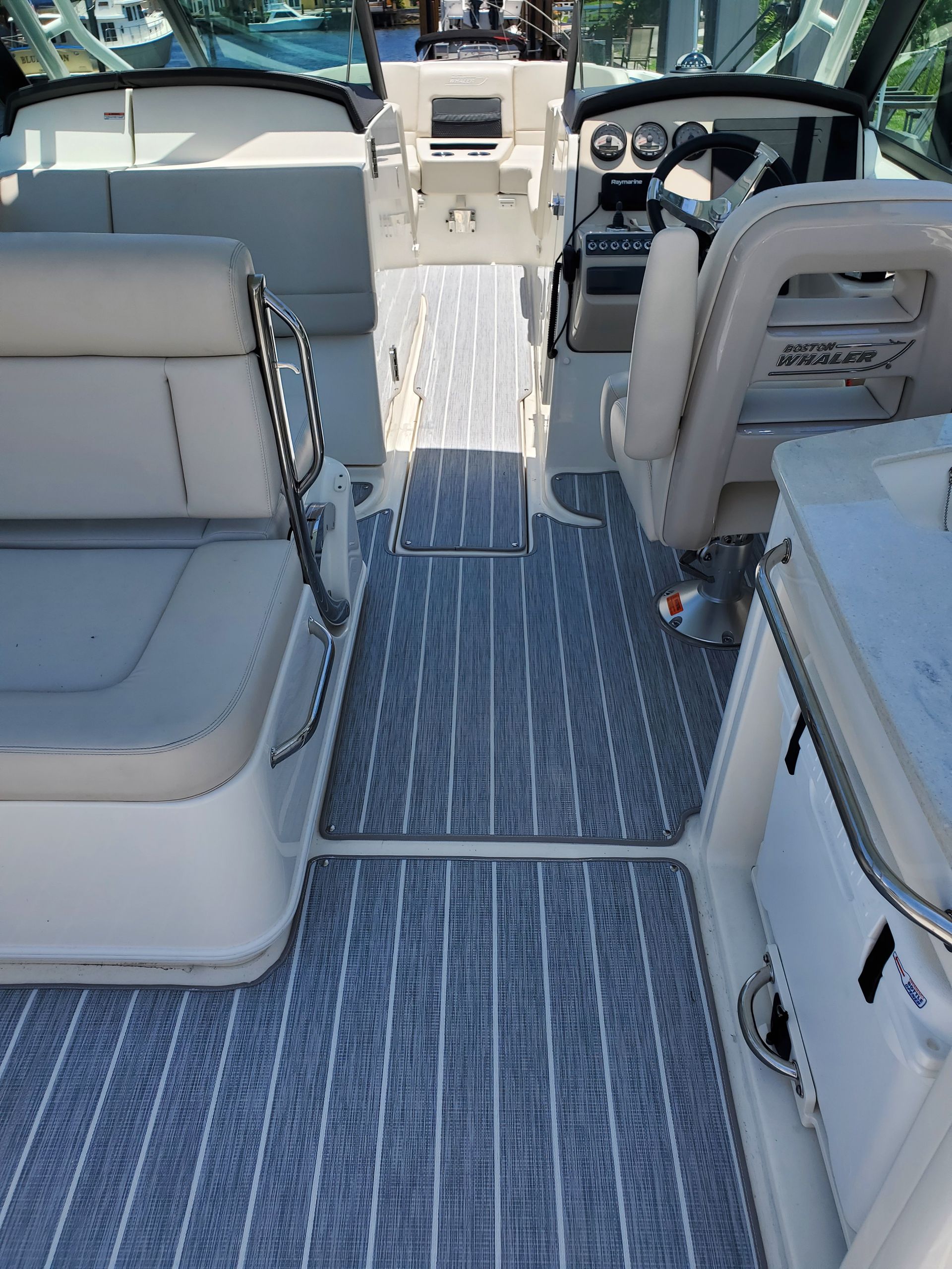 The inside of a boat with a gray and white striped floor.