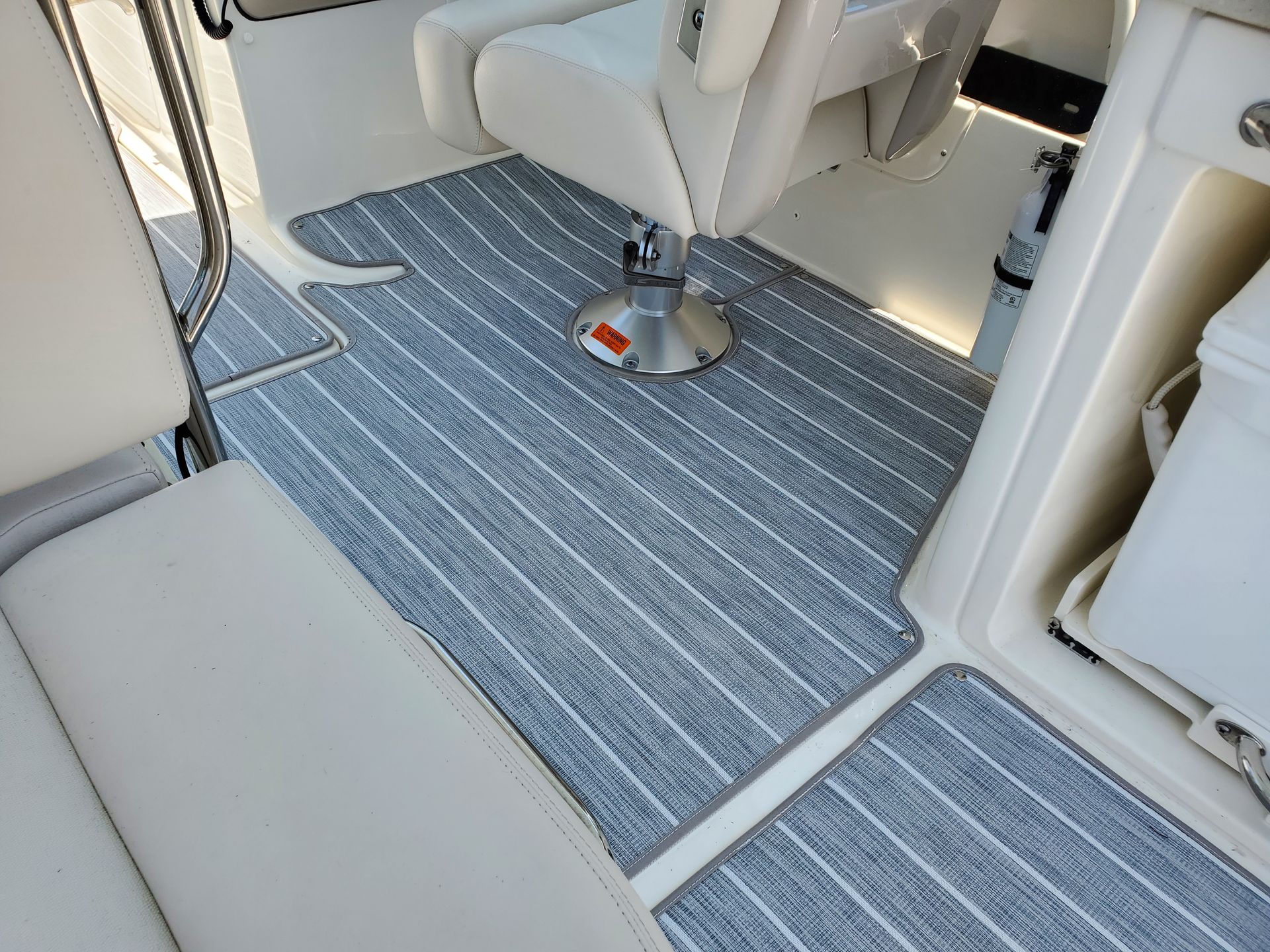 A boat with a chair and a rug on the floor.