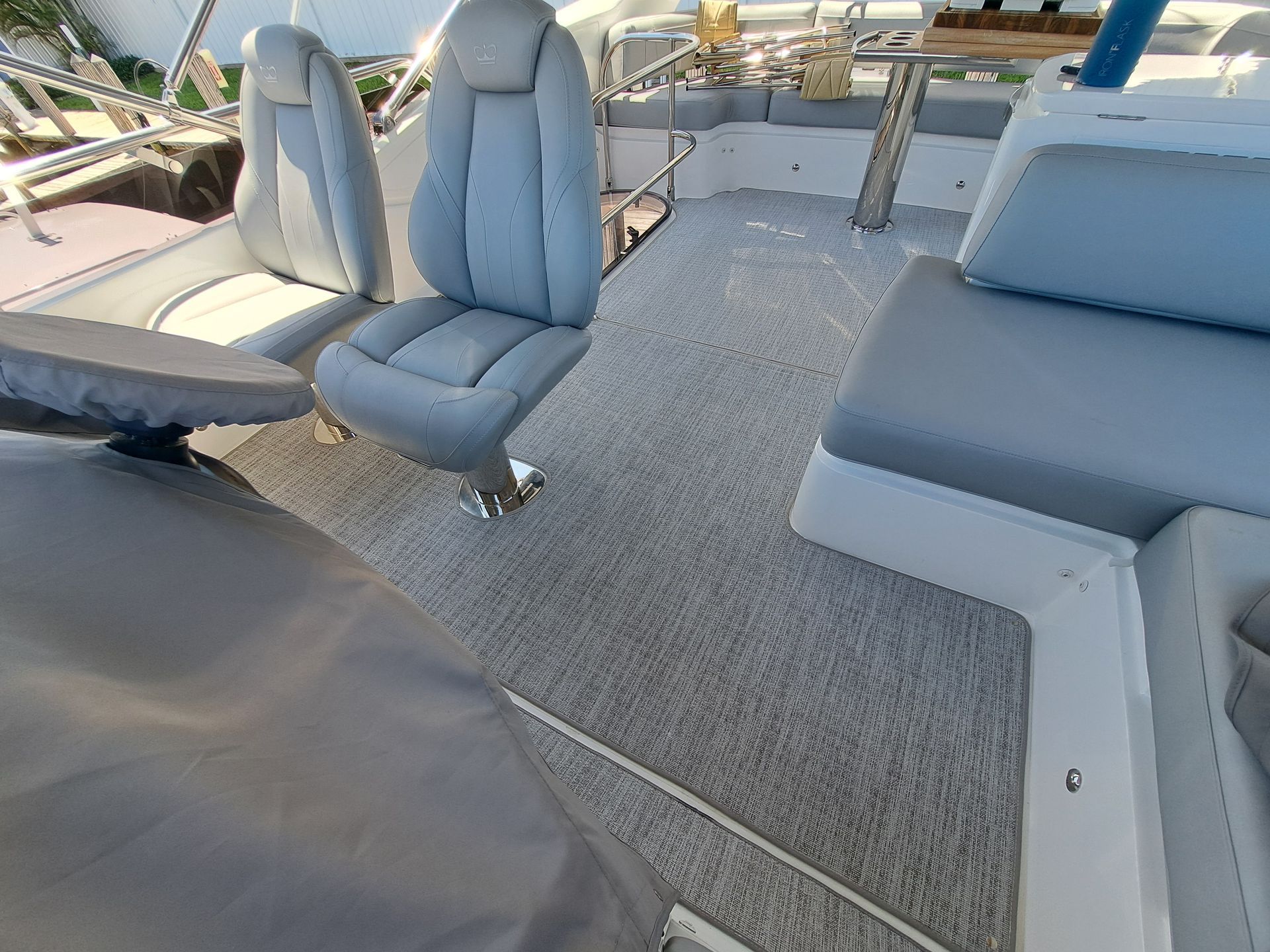 The inside of a boat with blue seats and a table.