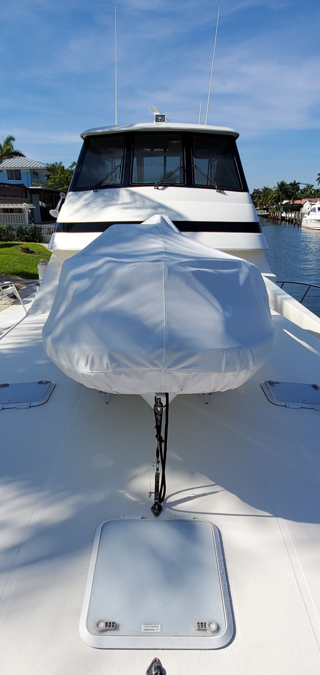 The front of a boat with a seat covered in plastic.