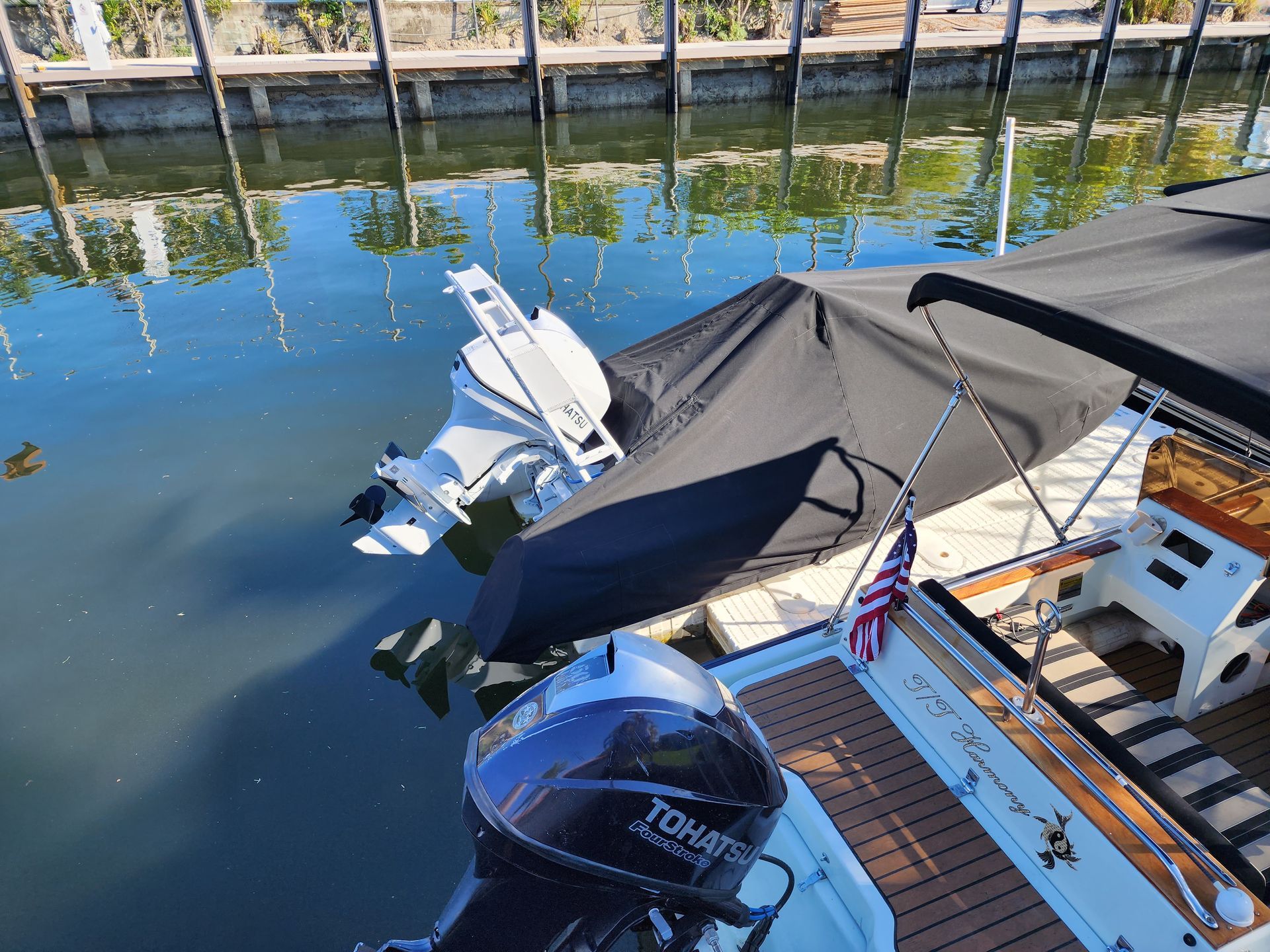 A boat with a tohatsu outboard motor is docked at a dock.