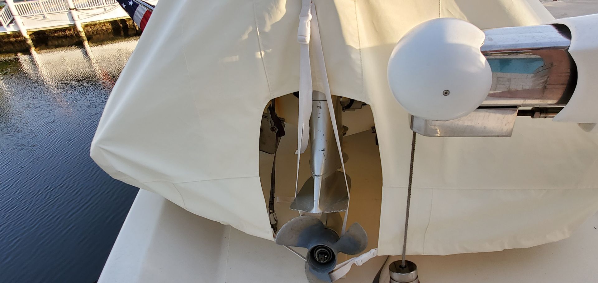 A white umbrella is sitting on the side of a boat.