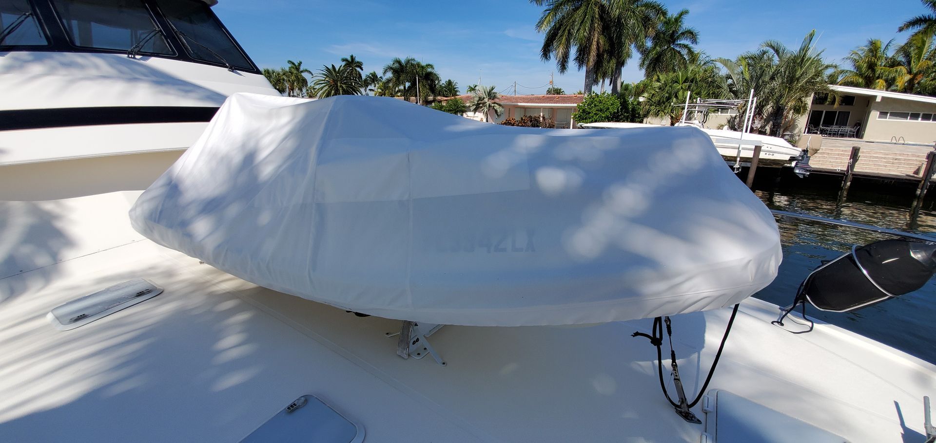 A white boat is covered in a white cover.