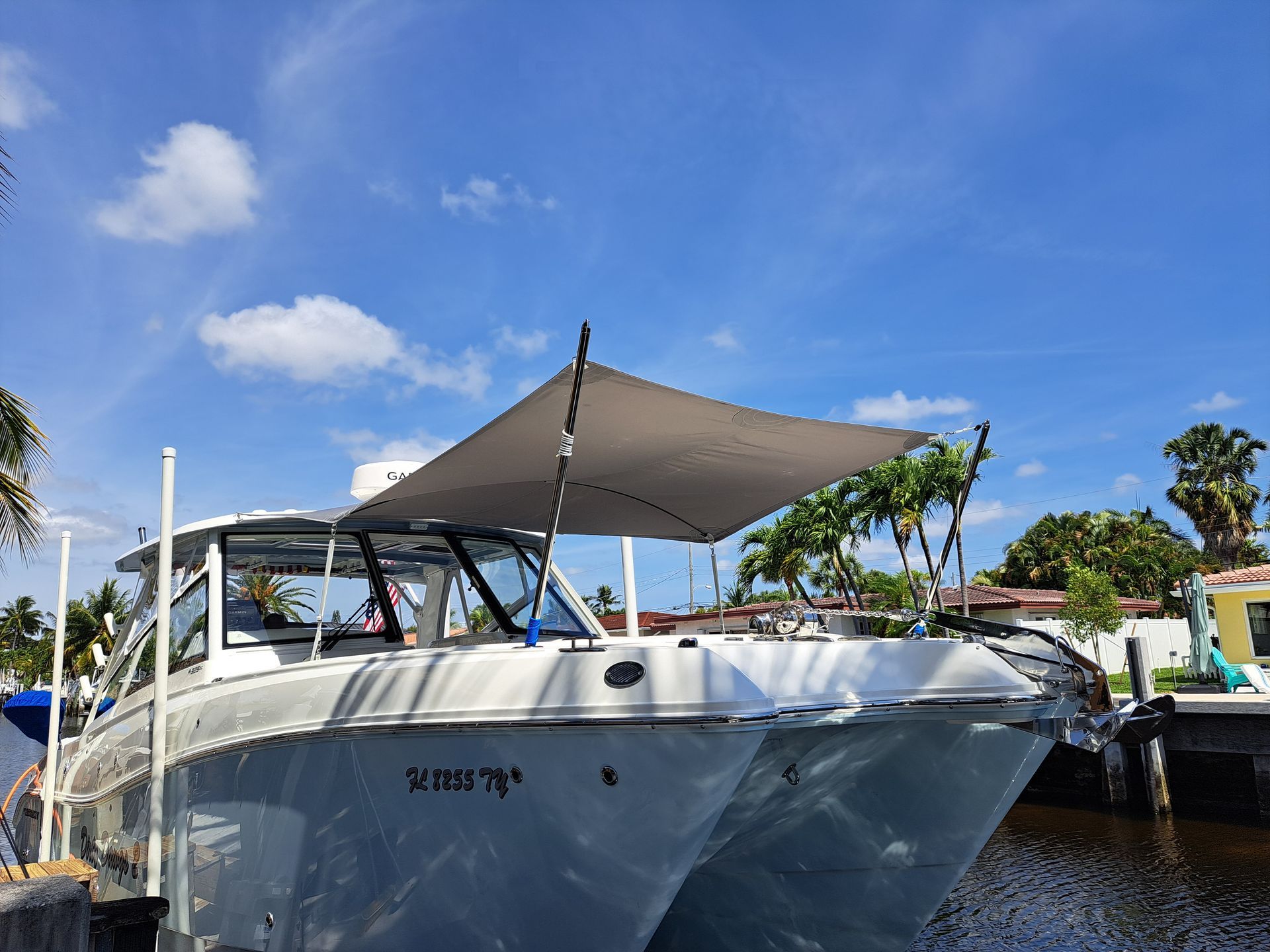 A boat with a canopy on top of it is docked in a marina.