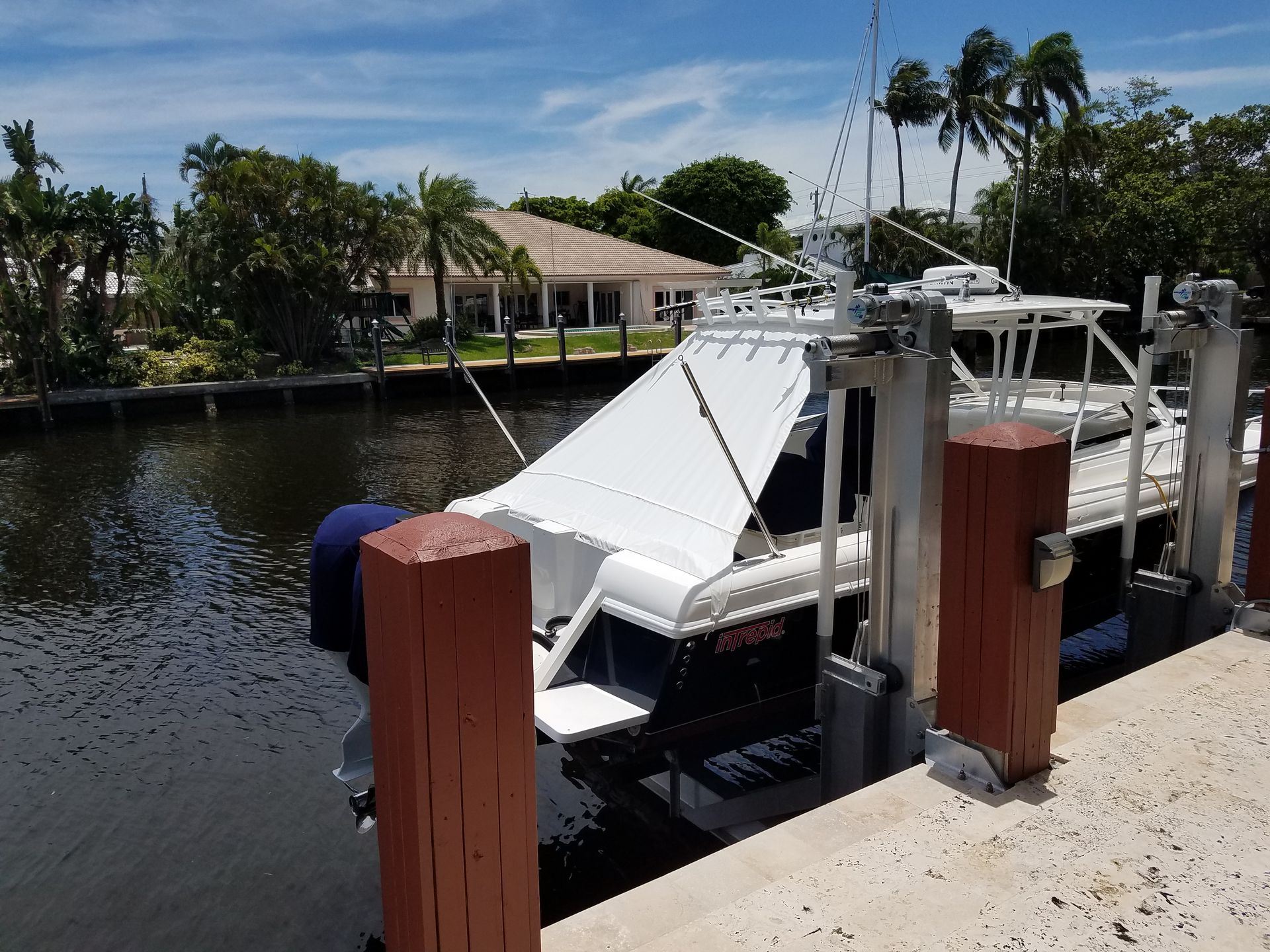 A boat is docked at a dock with a house in the background