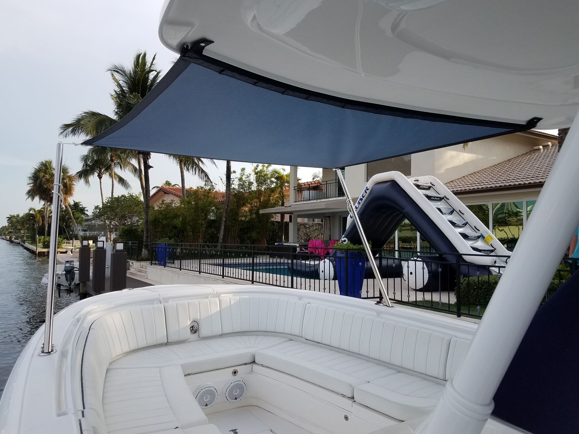 A white boat with a blue umbrella on top of it