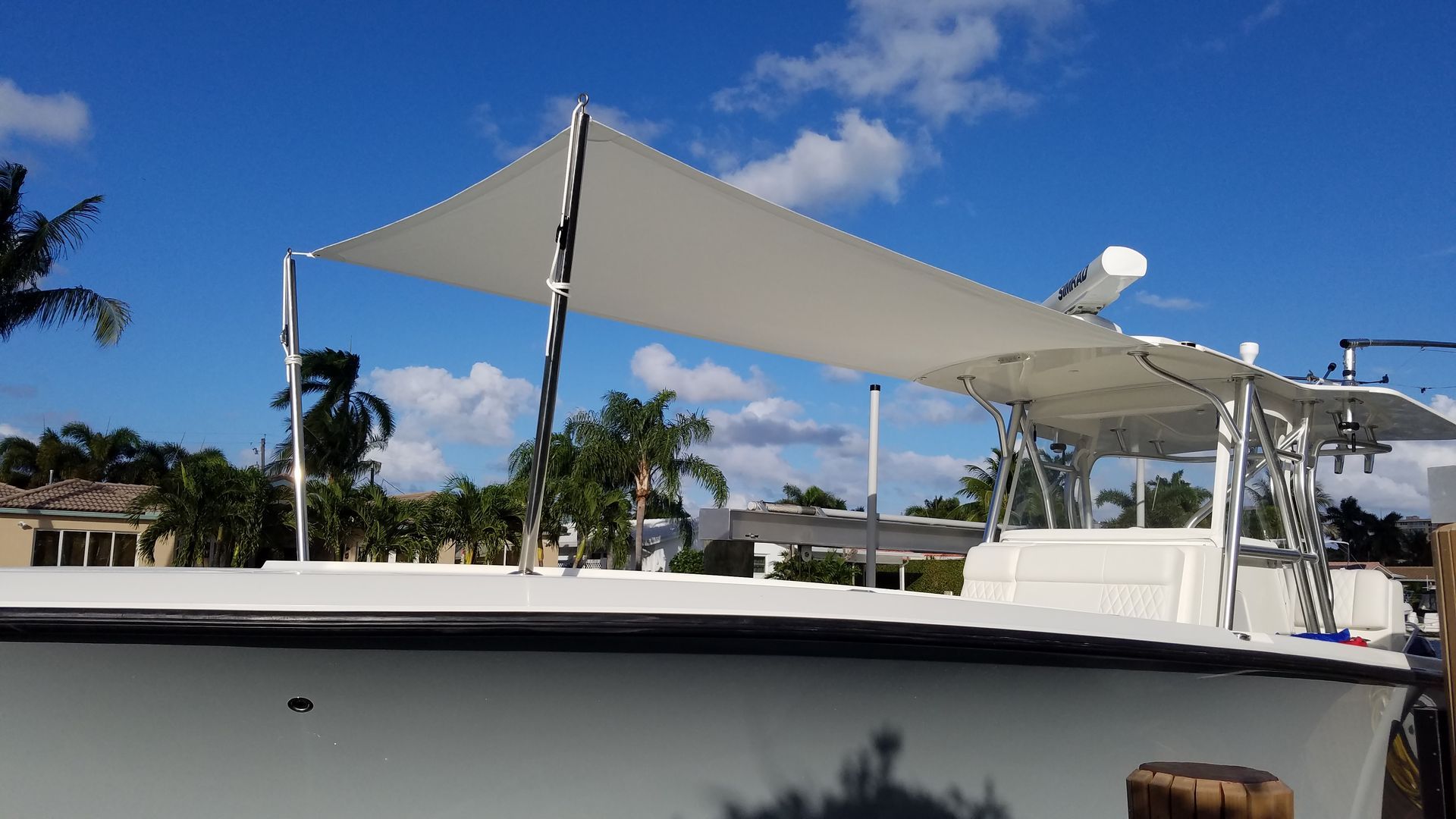 A white boat with a white umbrella on top of it