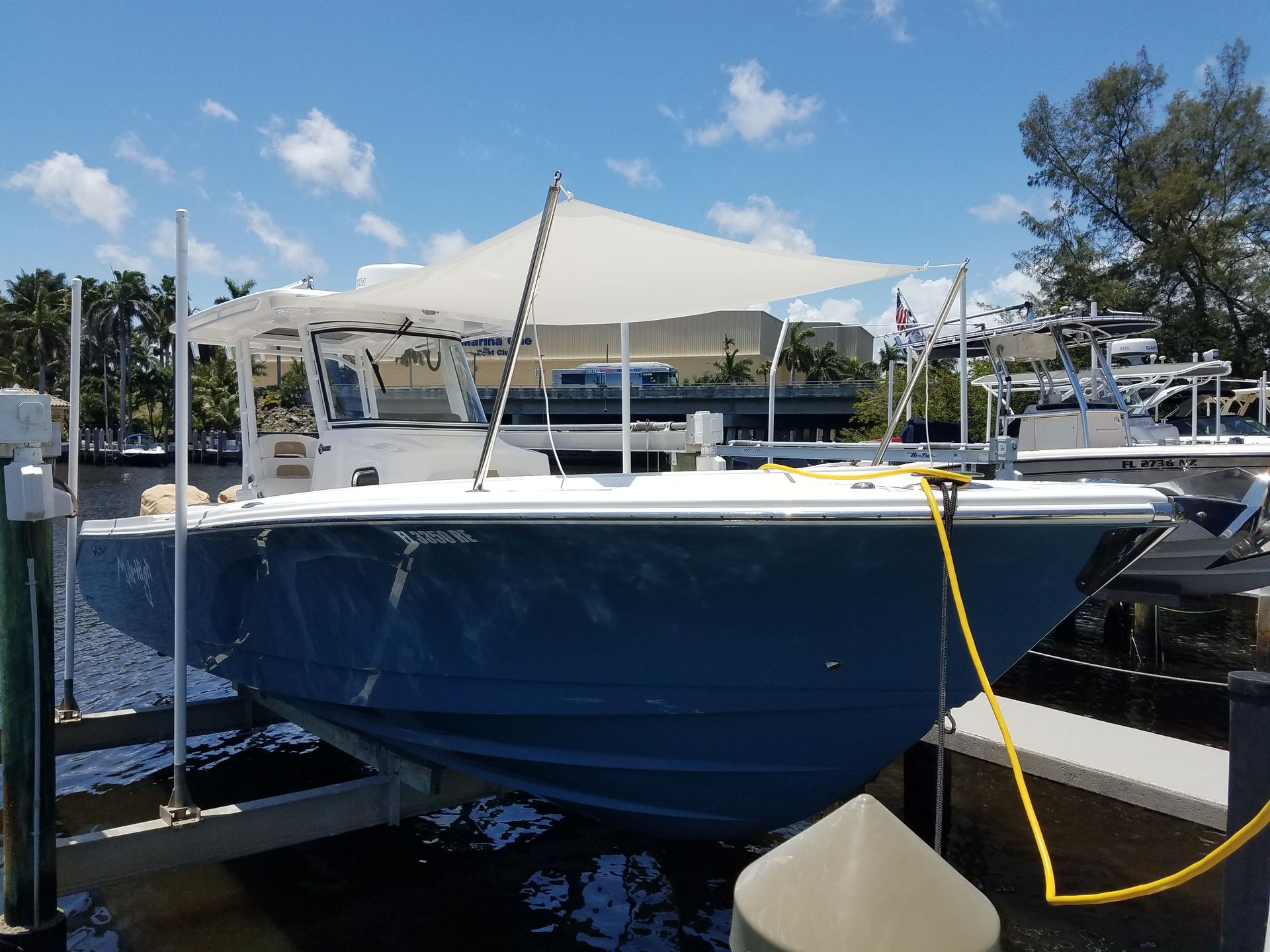 A boat is docked at a dock with a yellow hose attached to it