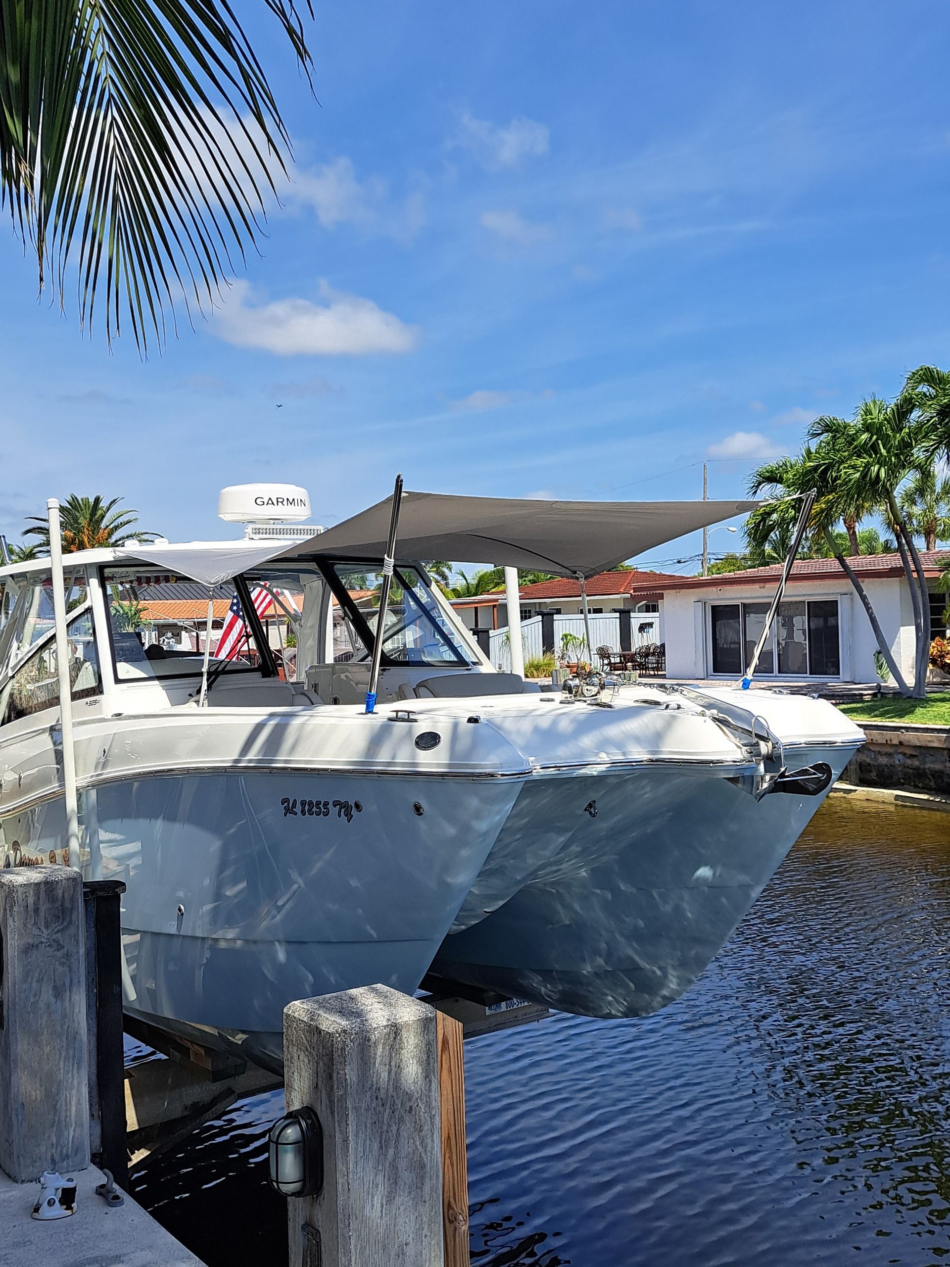 A boat is docked in a marina next to a house.