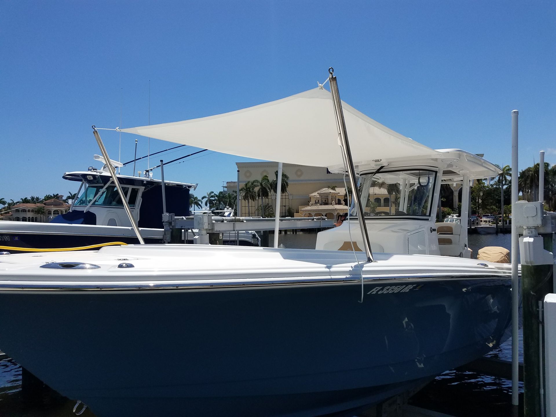 A boat with a sail on top of it is docked at a dock