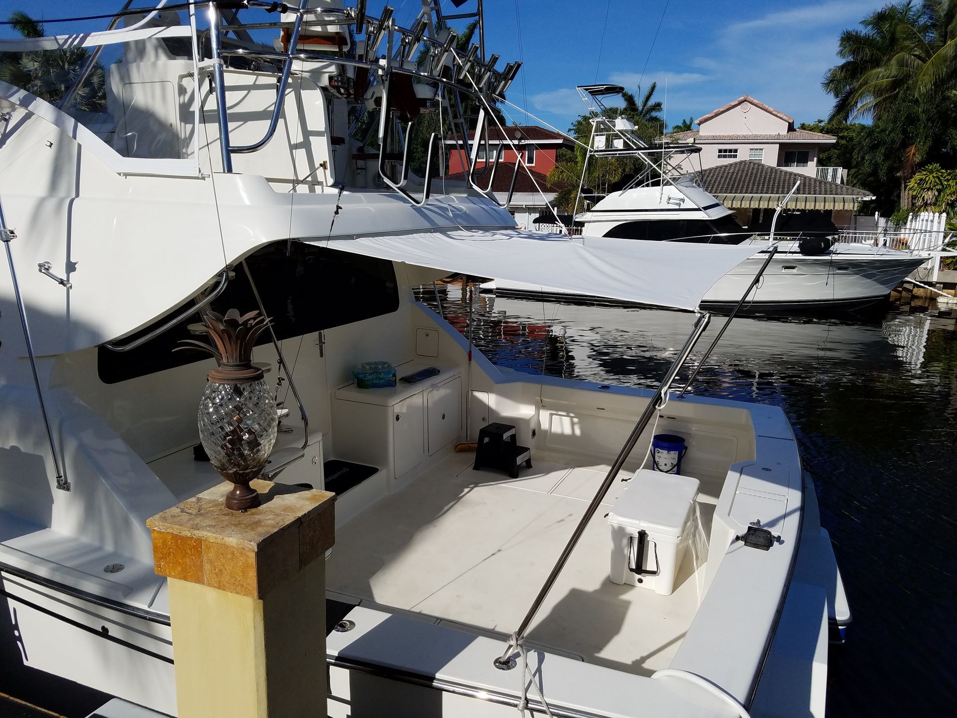 A white boat is docked in a marina with other boats