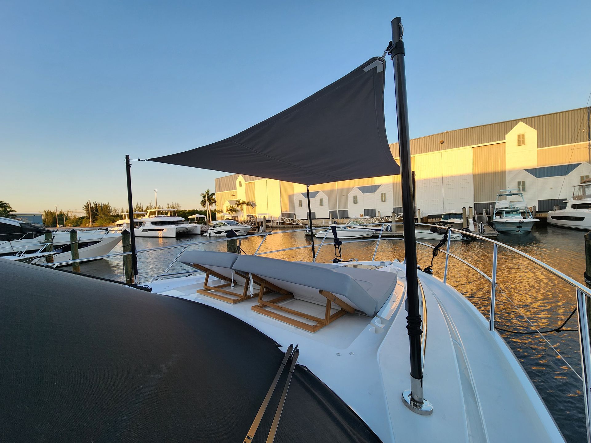 A boat is docked in a marina with a shade sail.