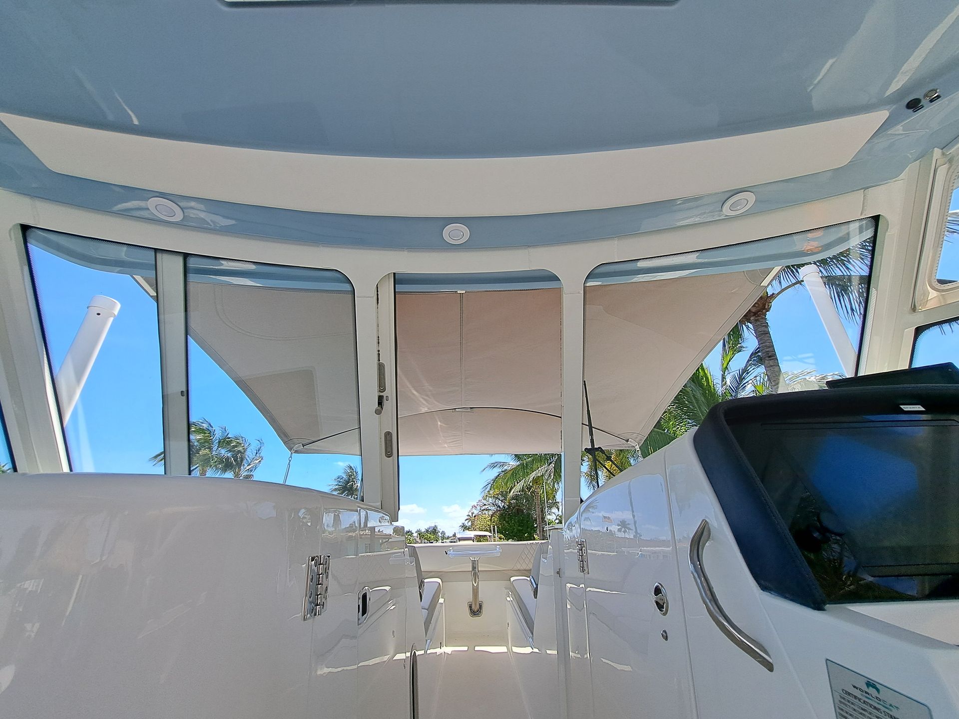 The inside of a boat with a blue sky and palm trees in the background