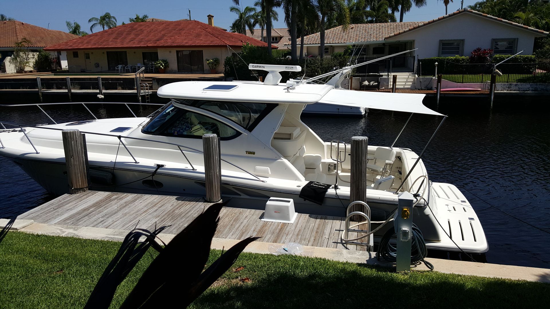 A boat is docked at a dock in front of a house