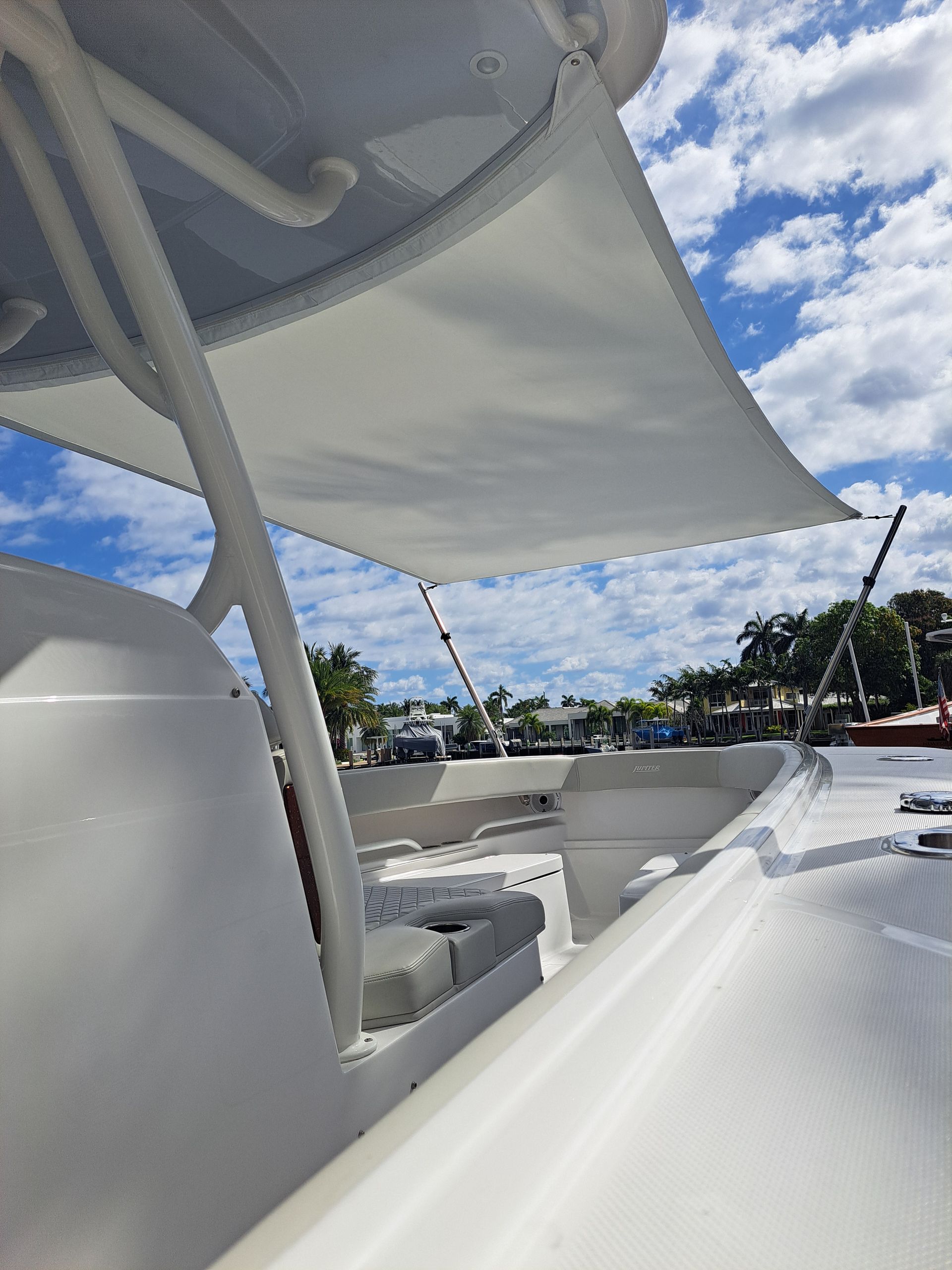 A white boat with a white canopy on top of it.
