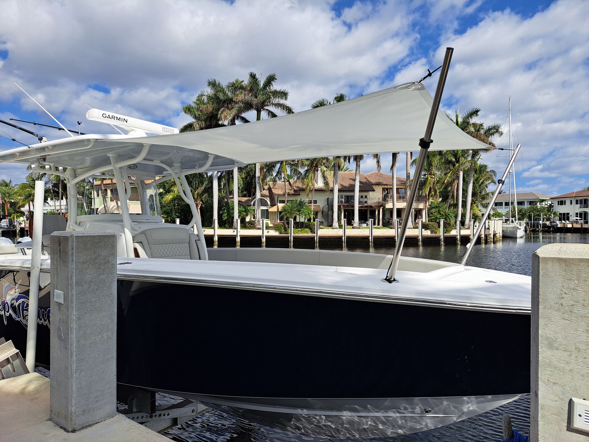 A boat with a white umbrella on top of it is docked in the water.