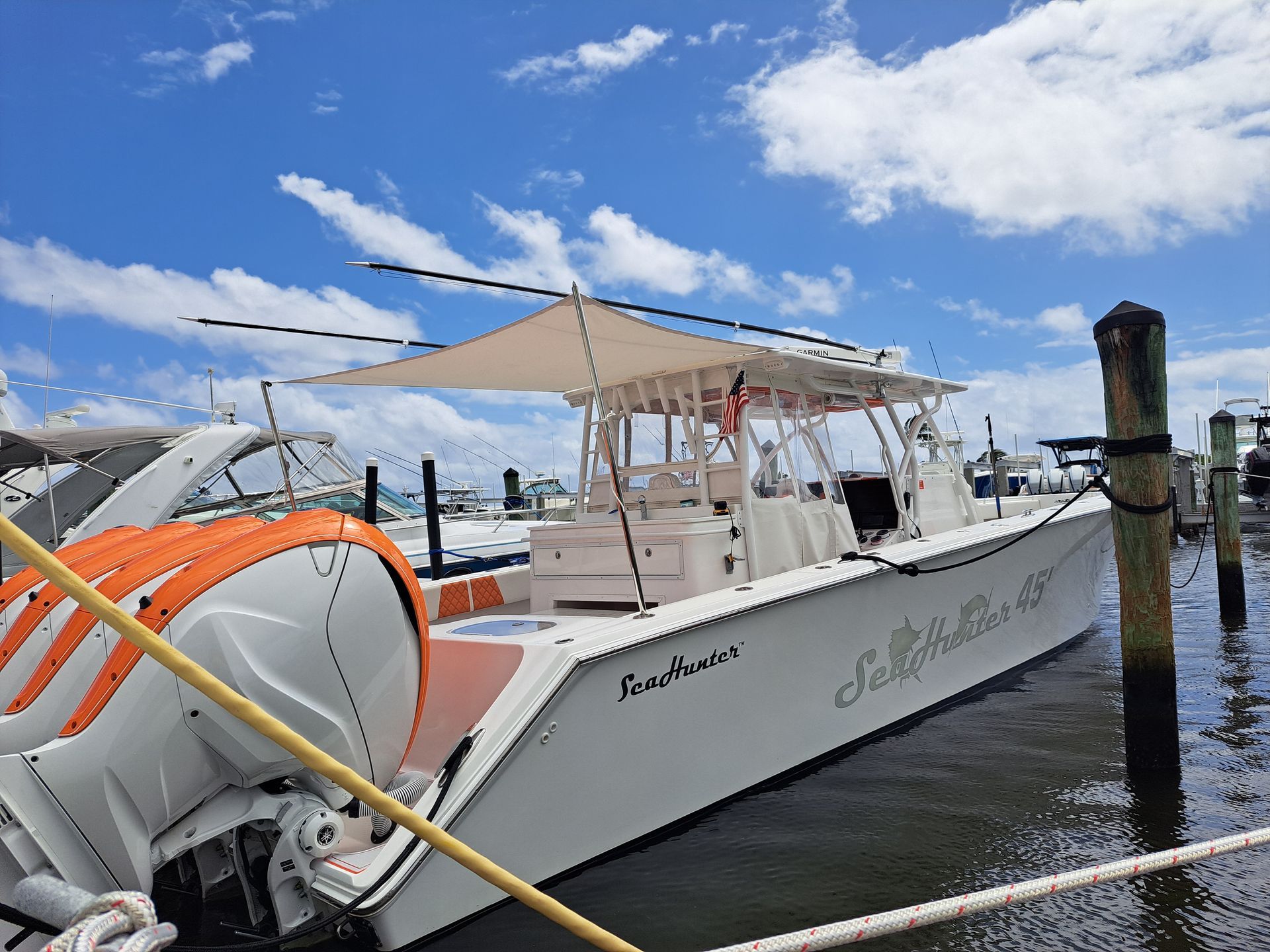 A white boat is docked at a dock in the water.
