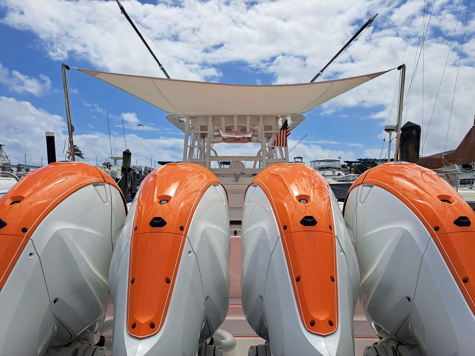 A white and orange boat with a sail on top of it