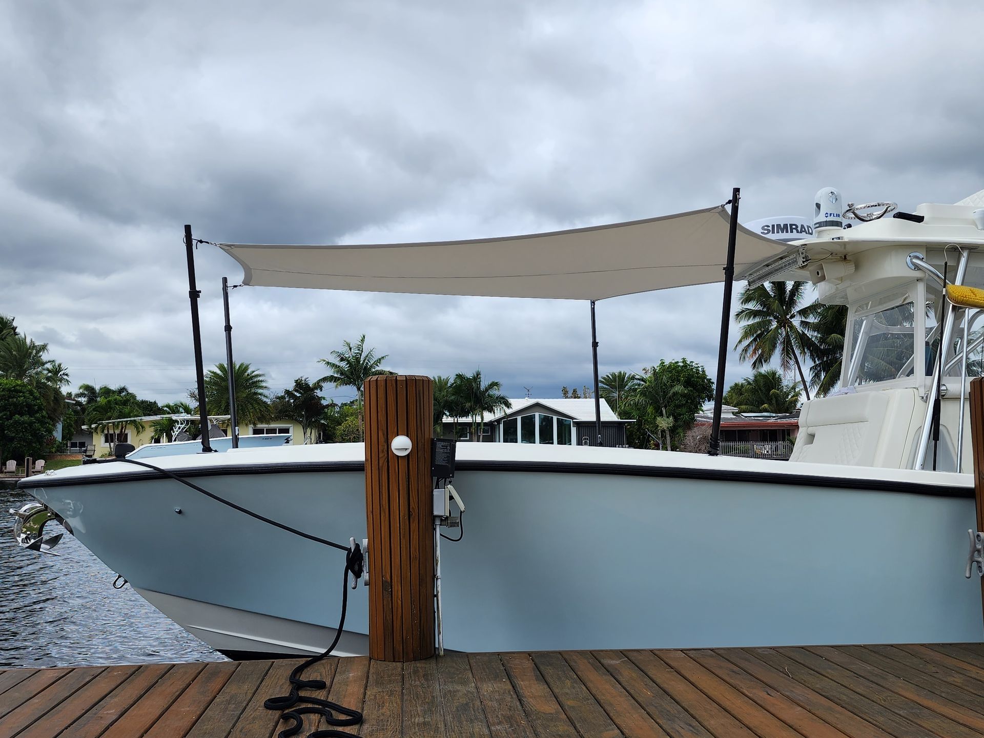 A boat is docked at a dock with a canopy on top of it