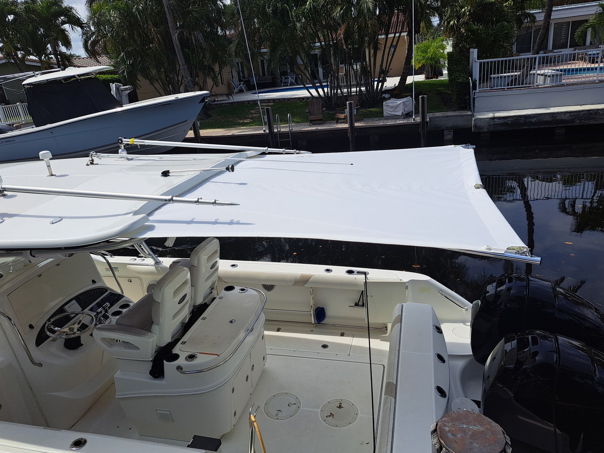 A boat with a canopy on top of it is docked at a dock.