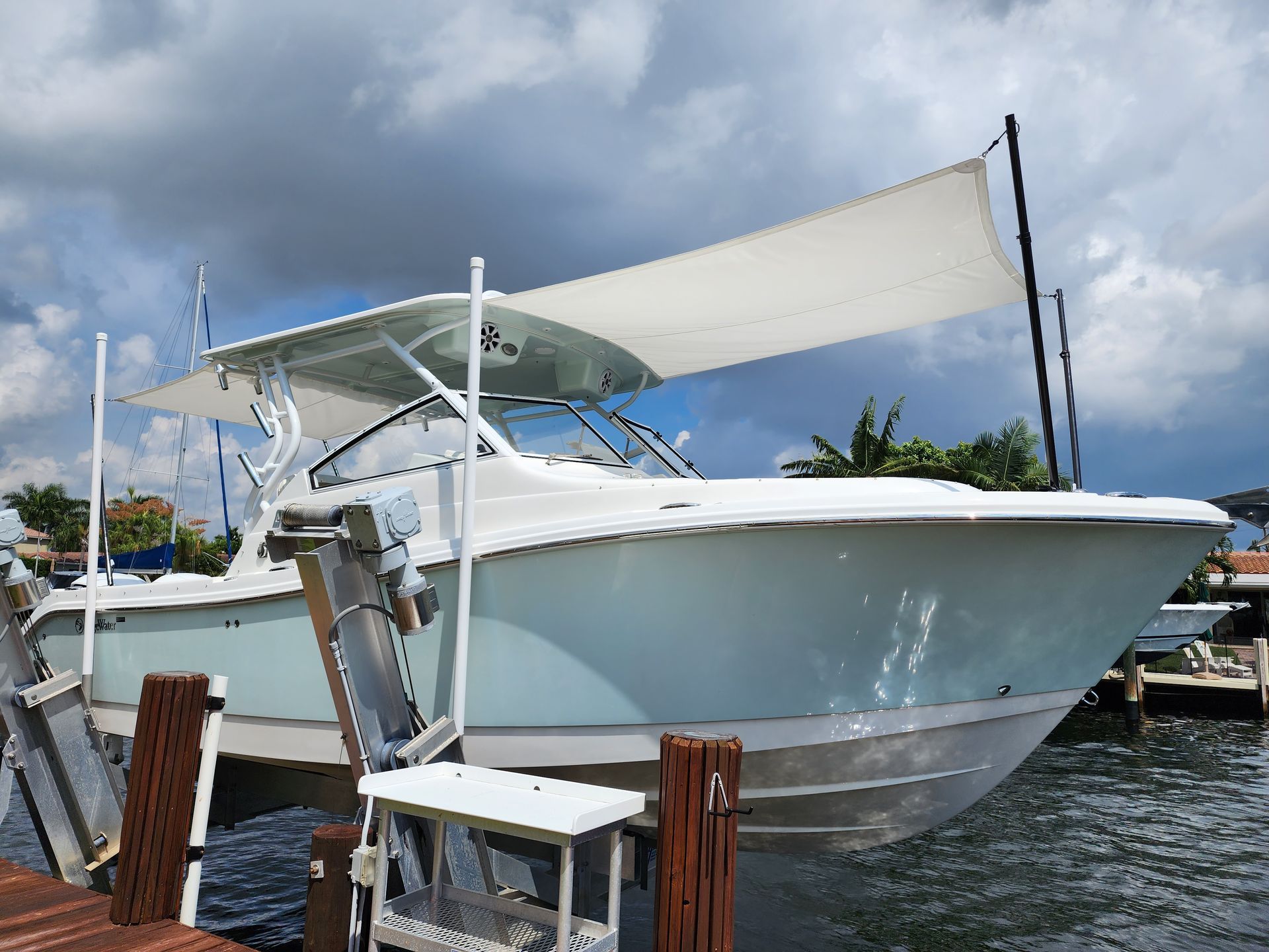 A boat is docked at a dock with a sail on top of it.