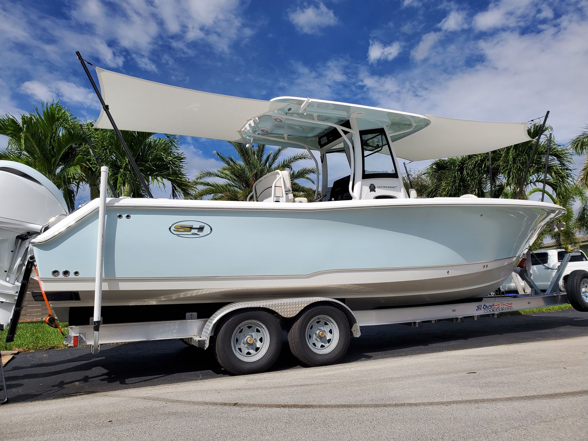 A boat is on a trailer with a sail on top of it.