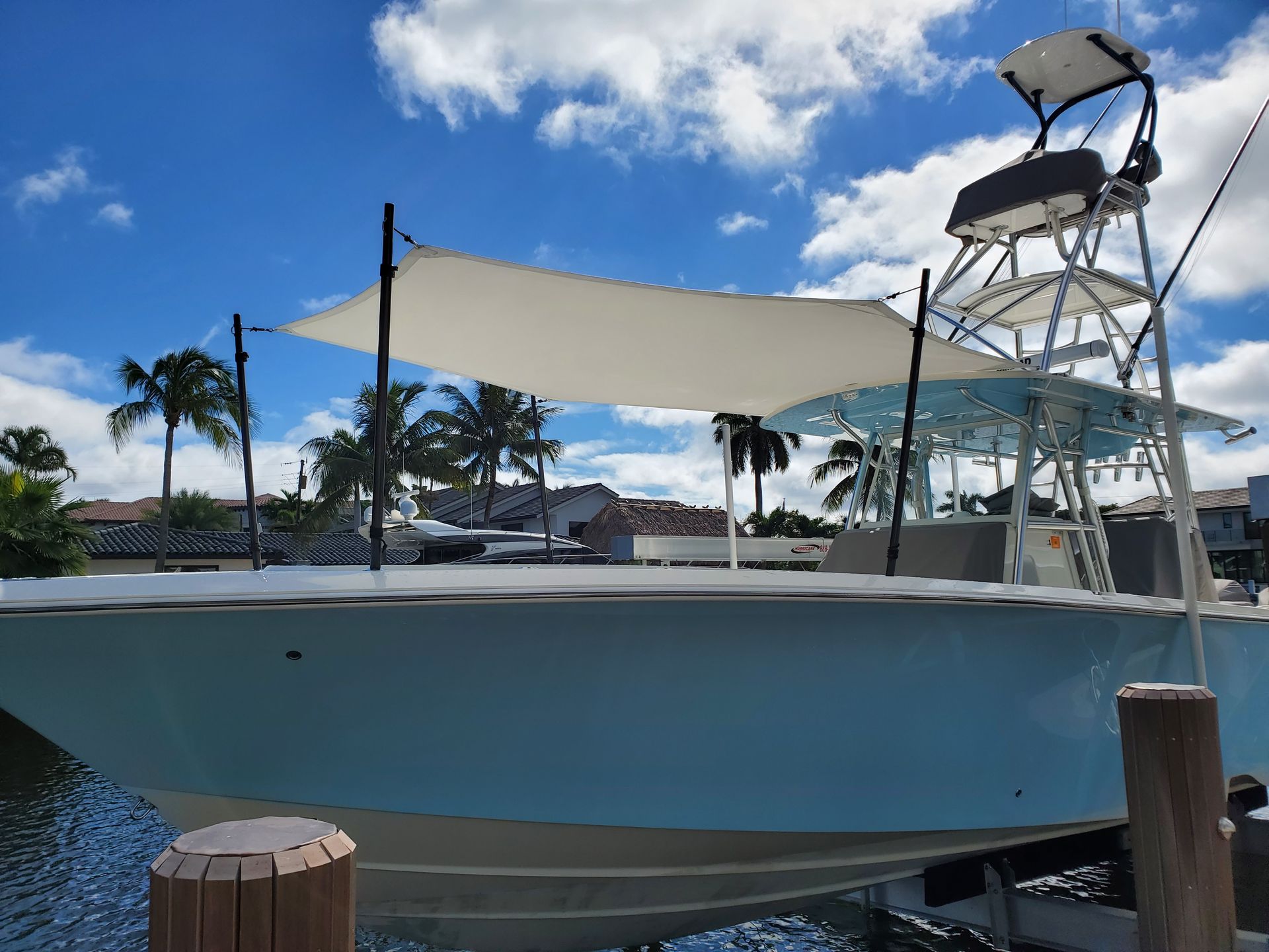 A boat with a sail on top of it is docked at a dock.