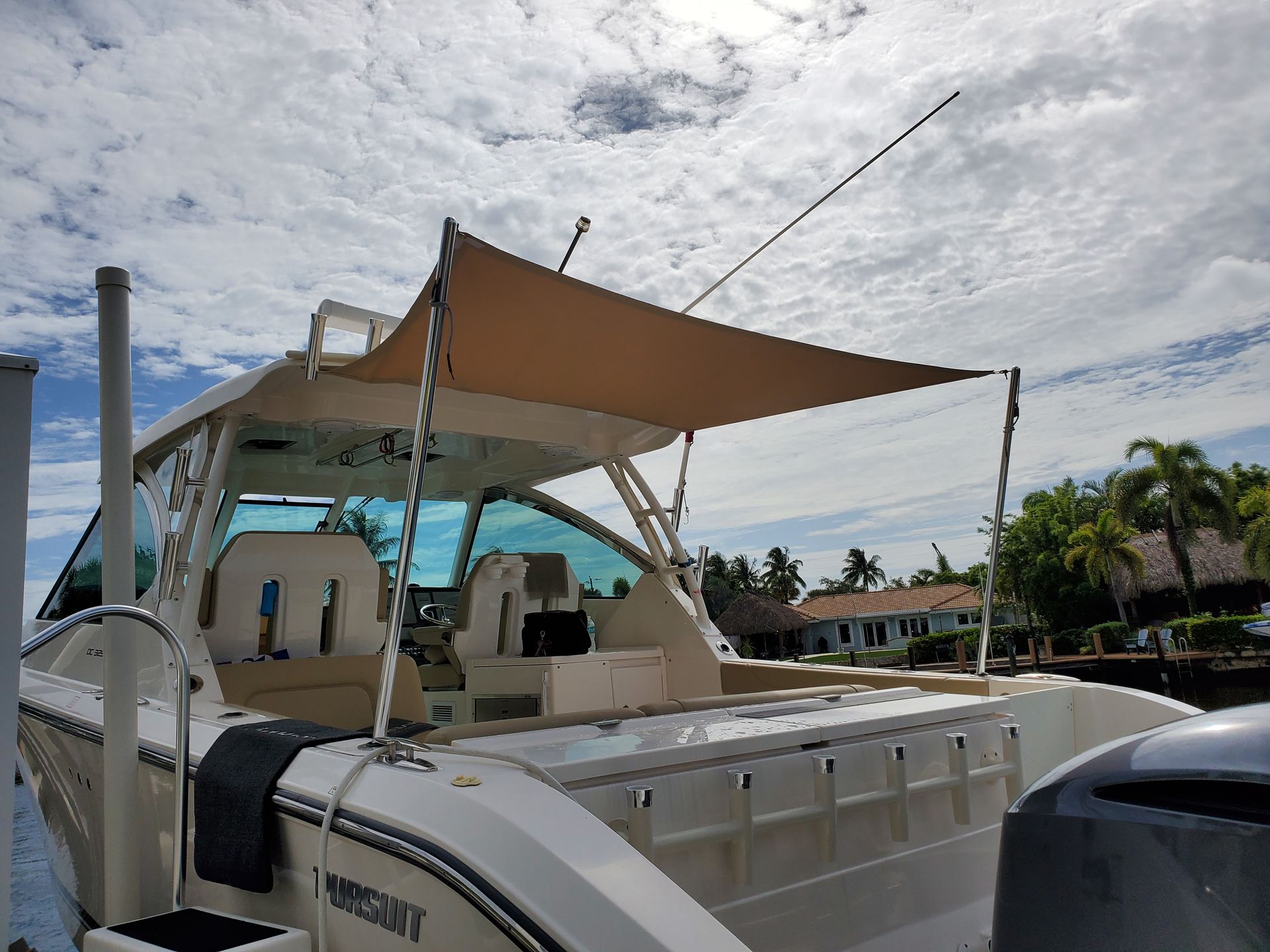 A boat with a canopy on top of it is docked in a marina.